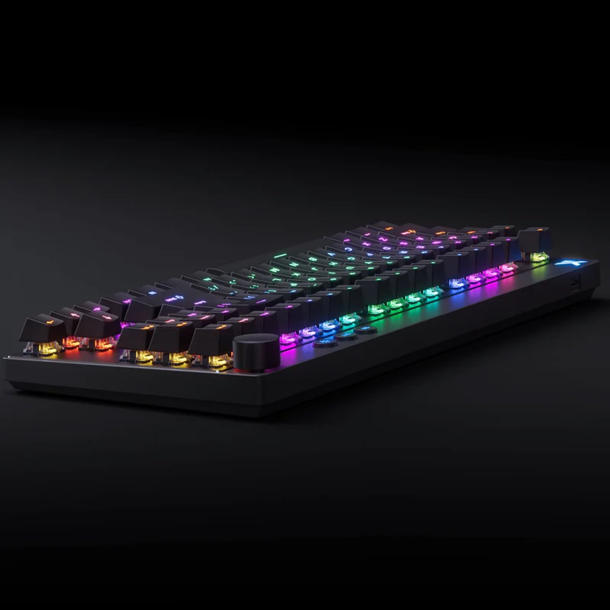 A black keyboard with colorful RGB lighting displayed on a dark background.