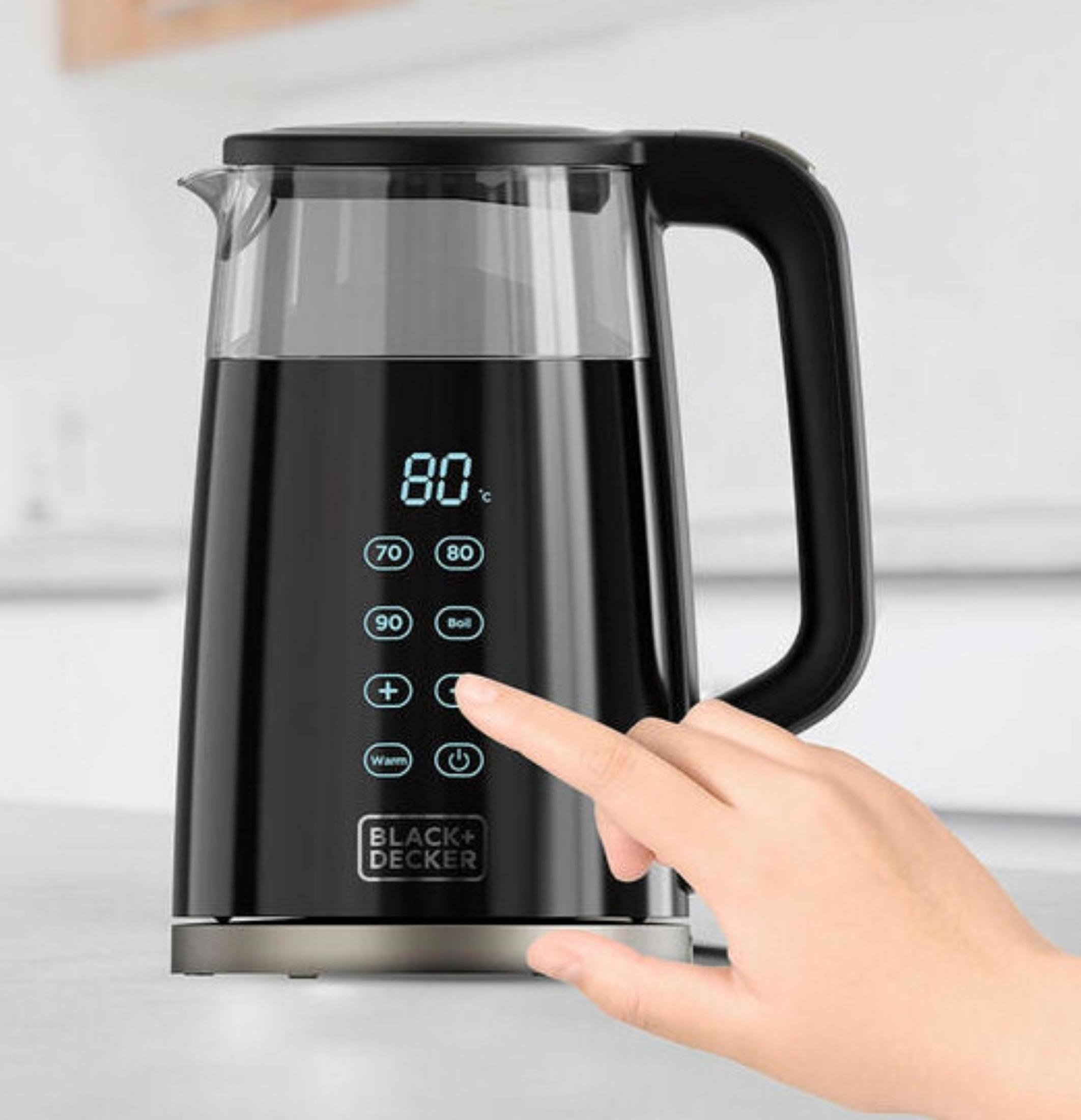 Una mano aziona un bollitore elettrico nero con display digitale a 80 gradi.