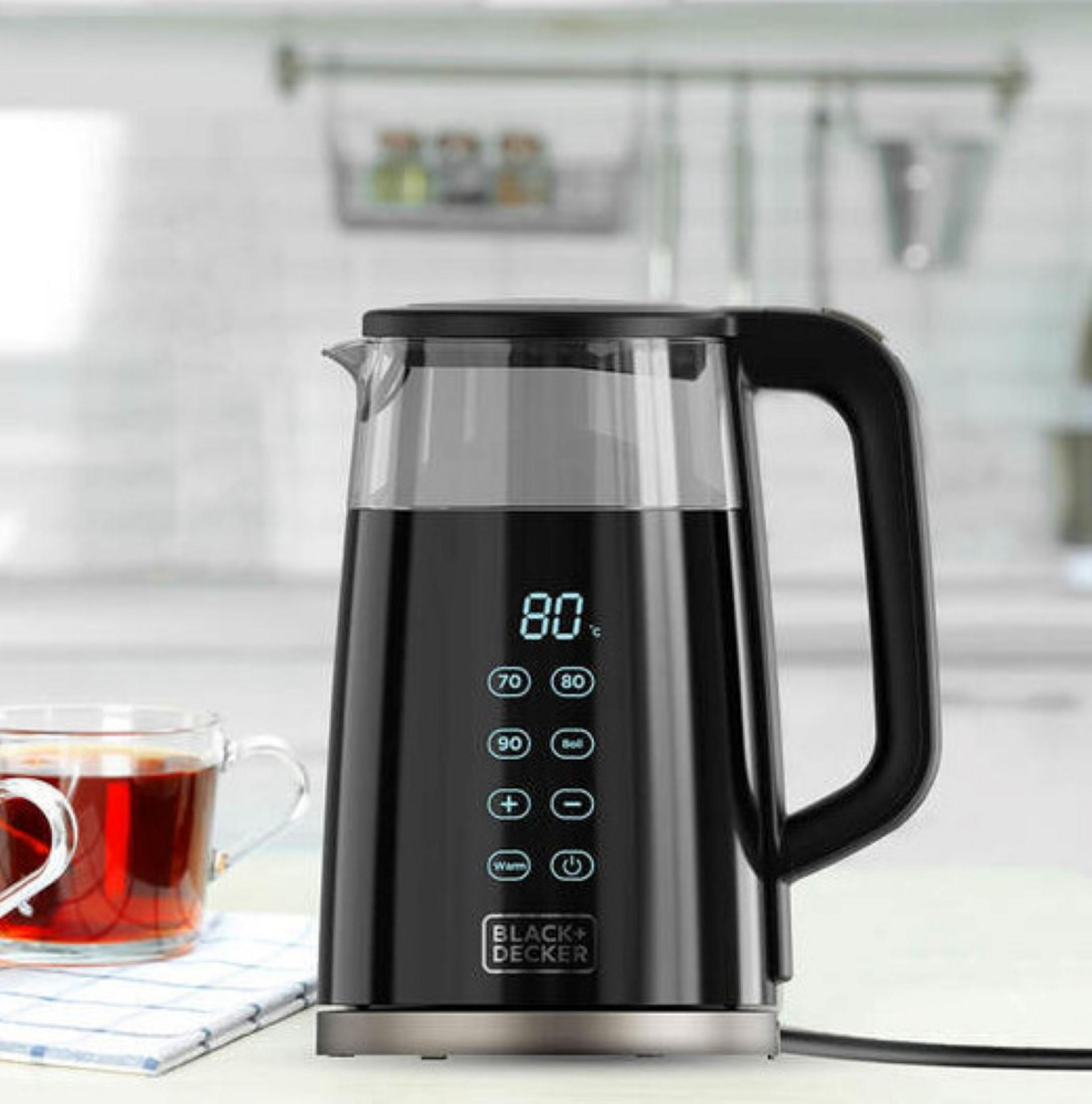 Bollitore elettrico nero con display digitale (80°C) accanto a una tazza di tè.