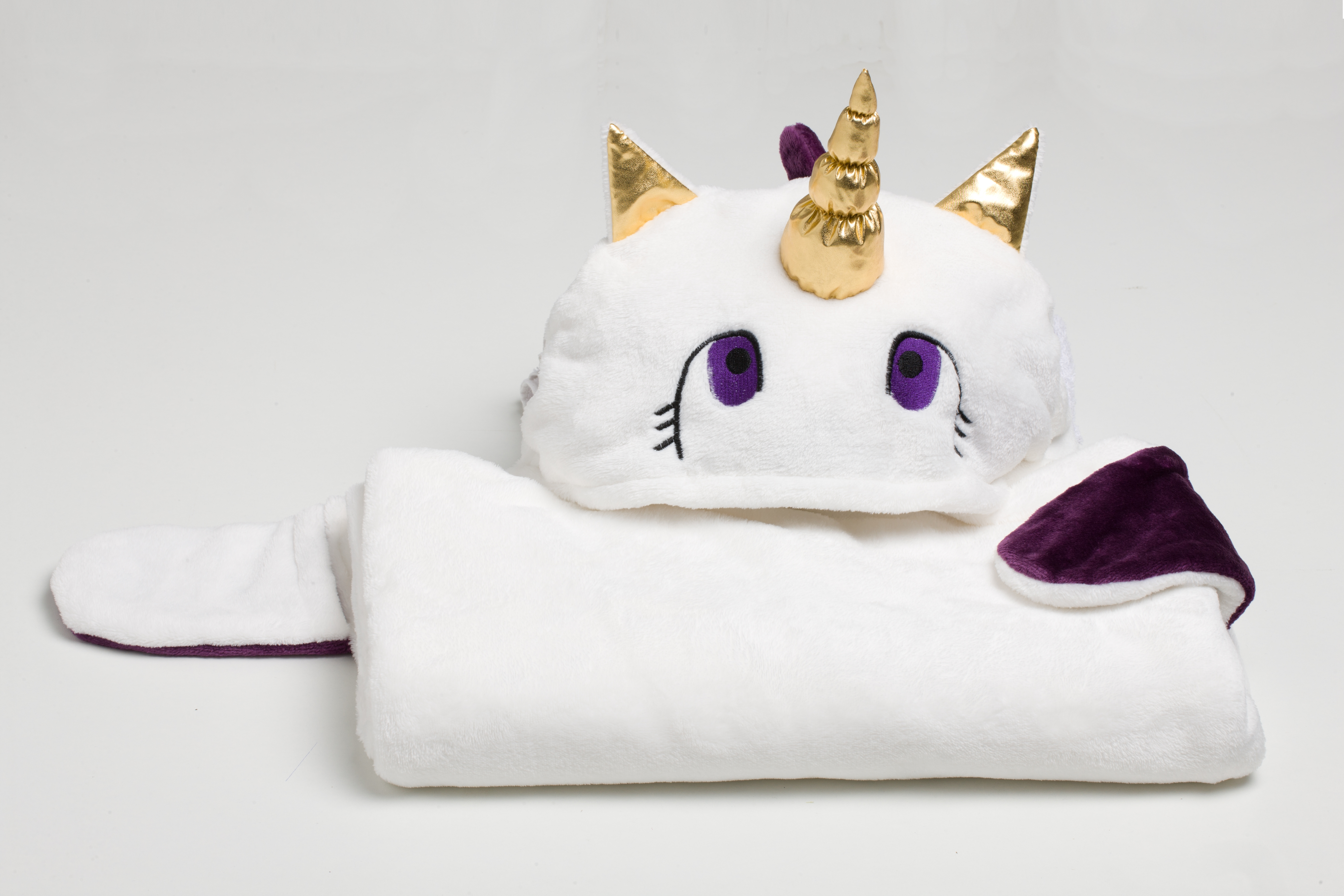 Un mantello bianco e soffice da unicorno con occhi viola e corno dorato.