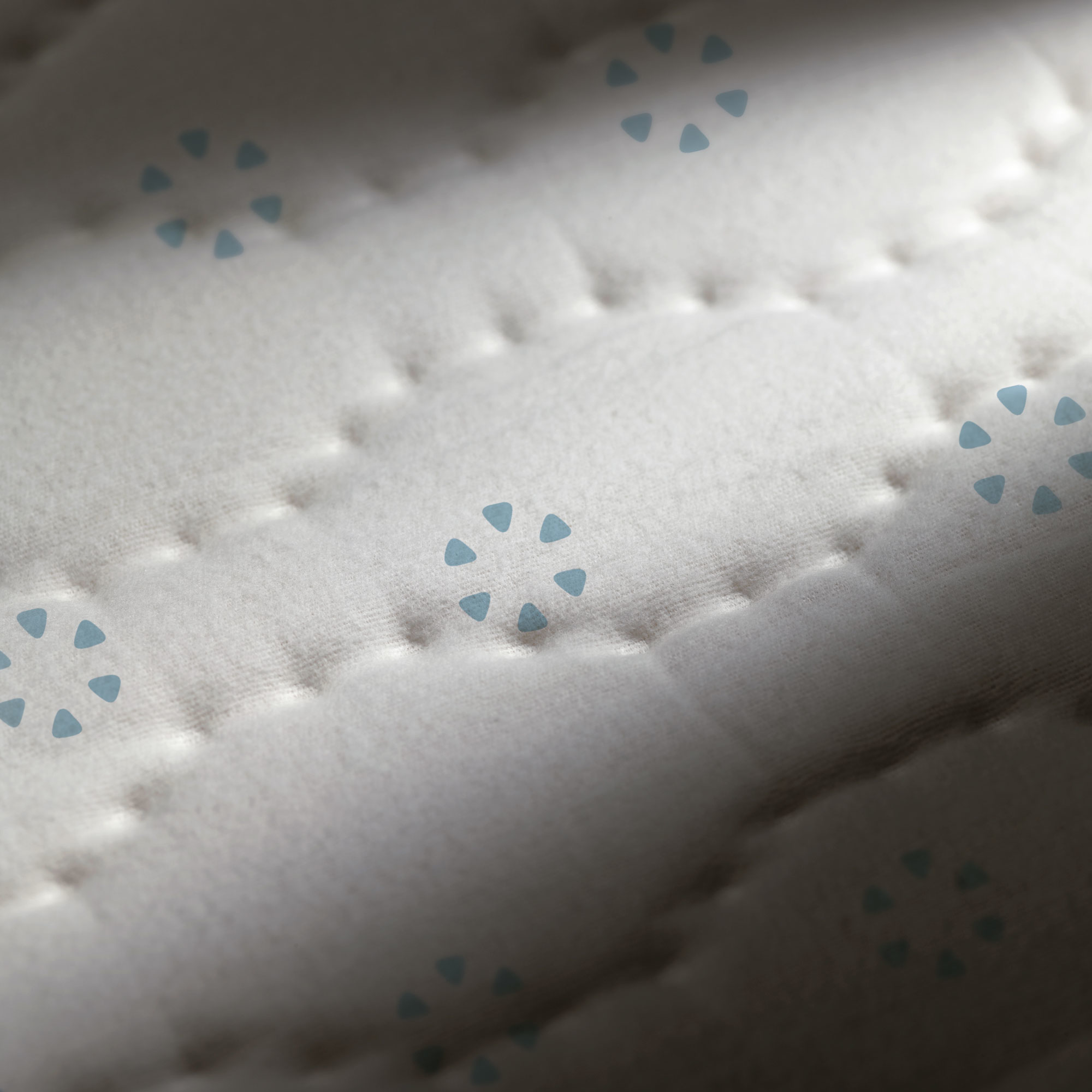 Tessuto bianco con motivo a rombi e triangoli blu.