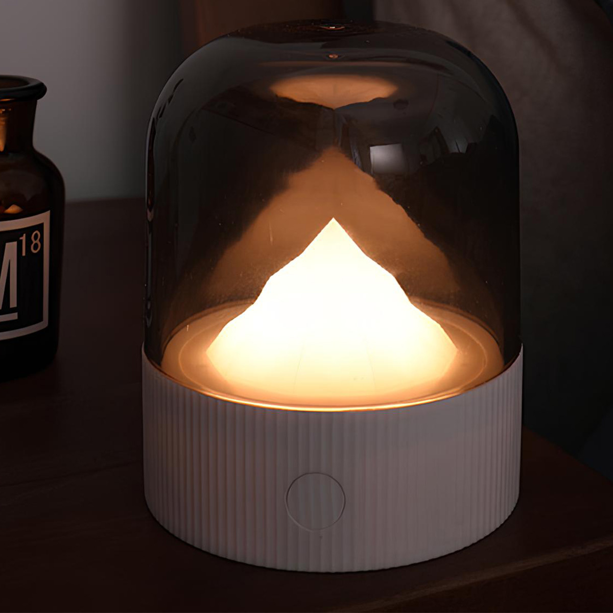 Eine weiße Lampe mit einem Rauchglas-Schirm und einer Flammenform im Inneren.