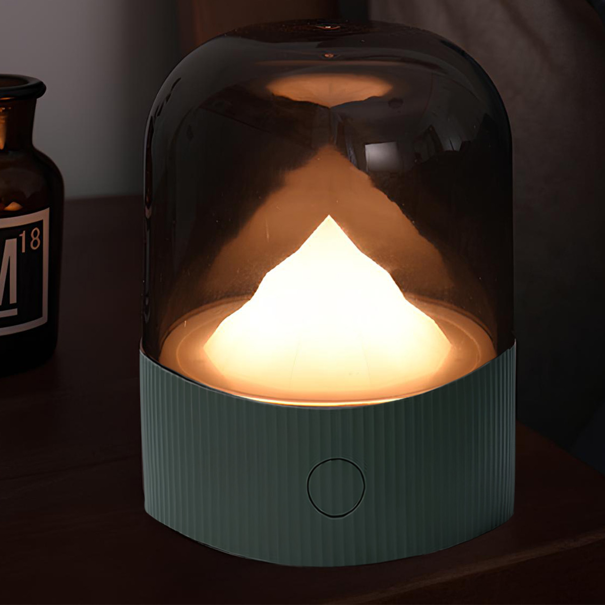Eine Tischlampe mit einem grünen Sockel und einem rauchfarbenen Lampenschirm, beleuchtet von innen.