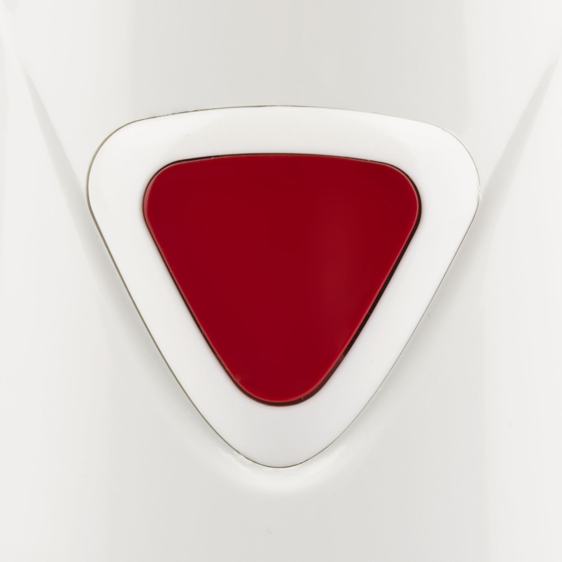 Czerwony trójkątny przycisk na białej powierzchni.