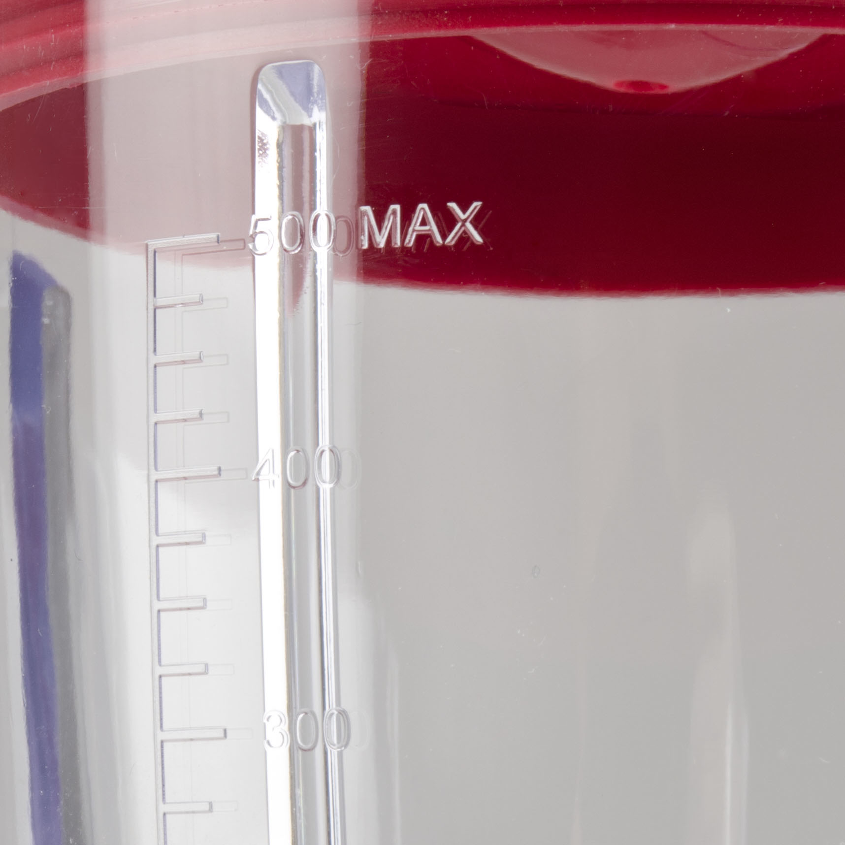 Czerwona pokrywa na przezroczystym pojemniku z miarką.