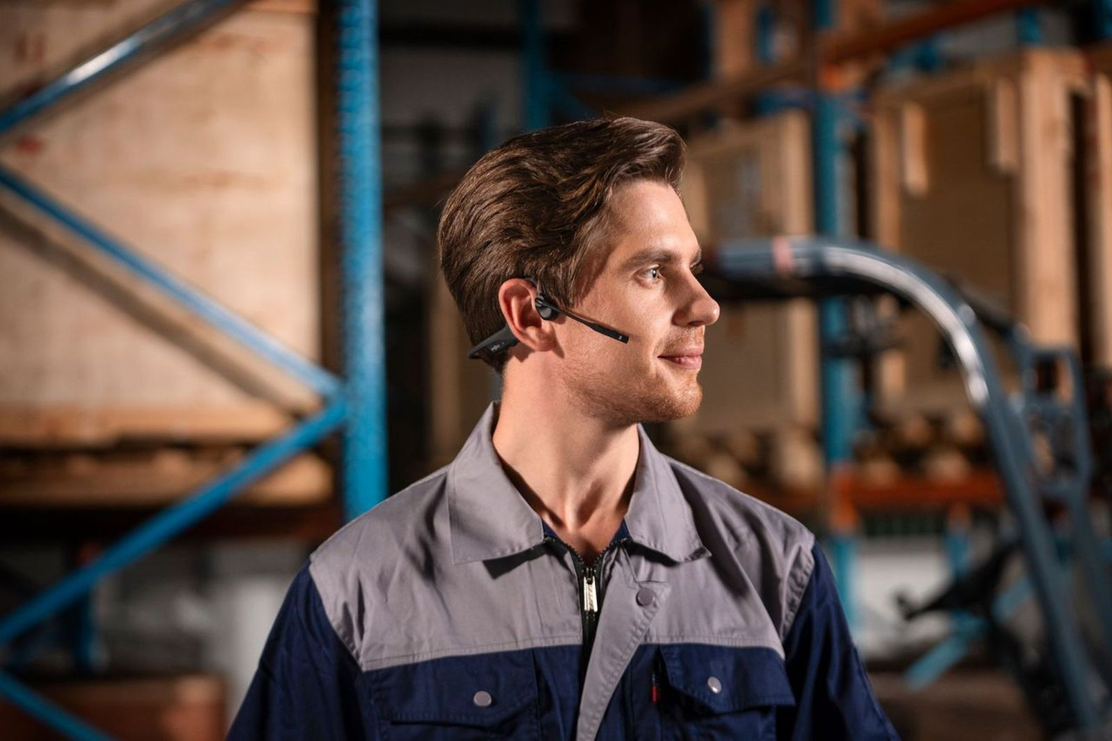 Mężczyzna w zestawie słuchawkowym w magazynie, patrzący w prawo.