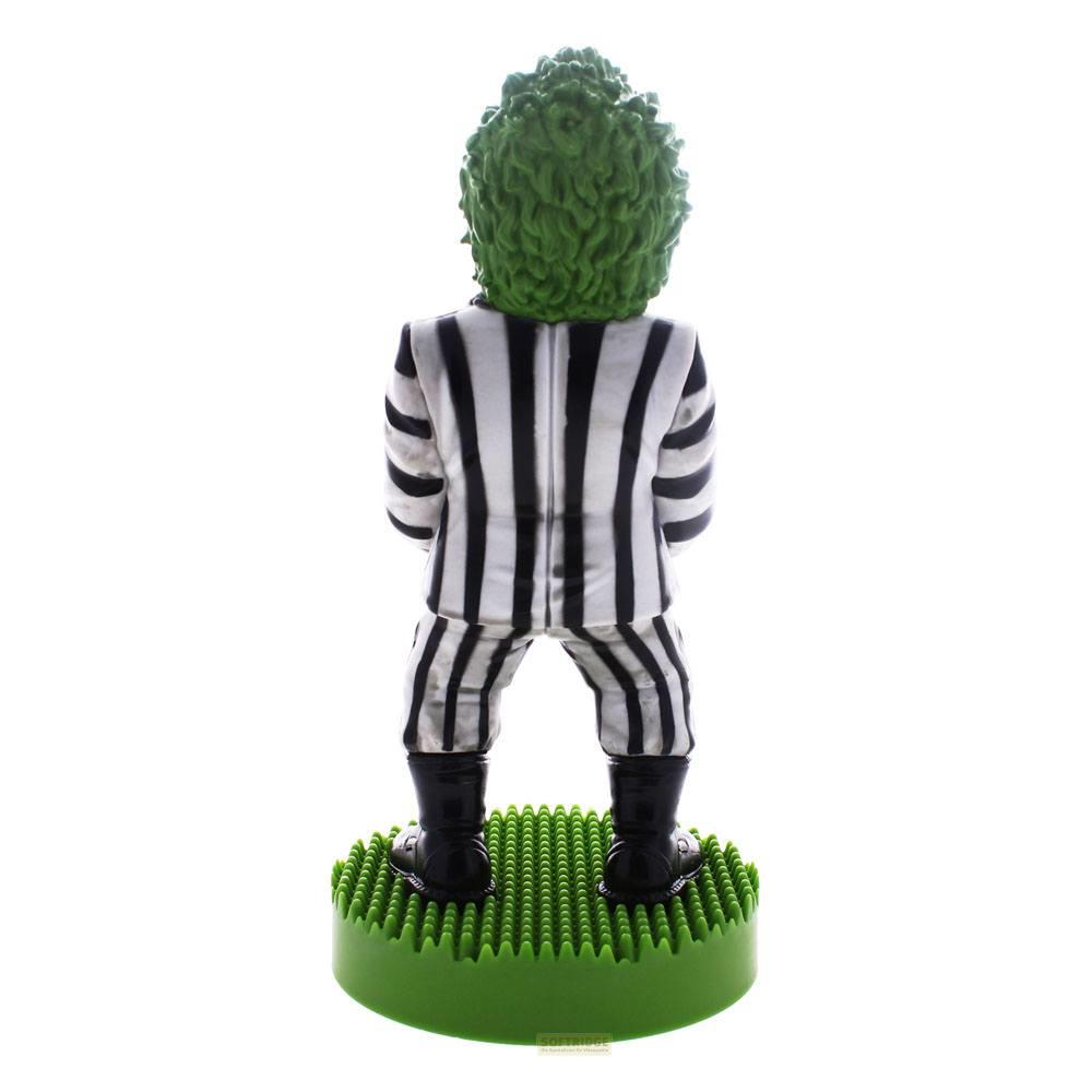 Figur mit grünem Haar, schwarz-weißer Anzug, auf grünem Sockel.