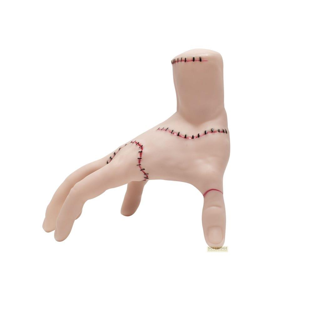 Une figure pâle en forme de main avec des coutures noires et rouges.