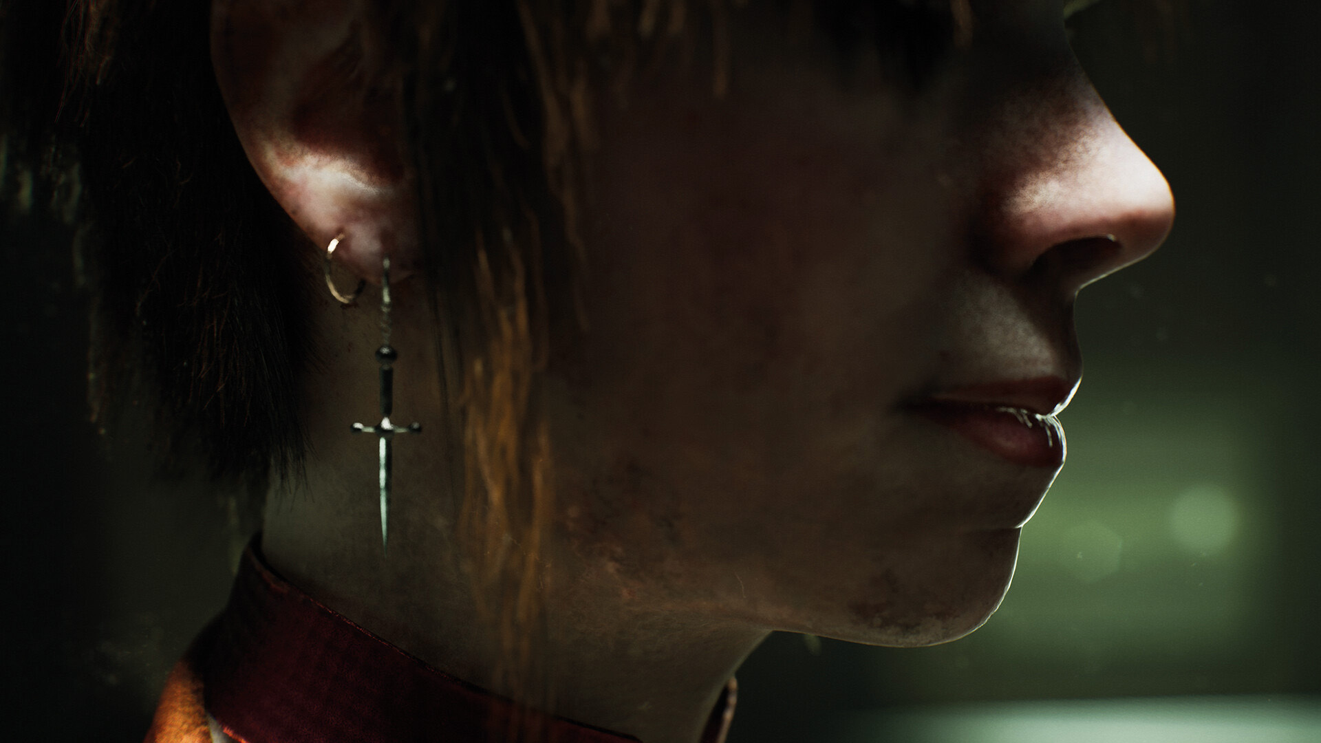 Zbliżenie twarzy z kolczykiem w kształcie krzyża i kołnierzykiem czerwonej koszuli.