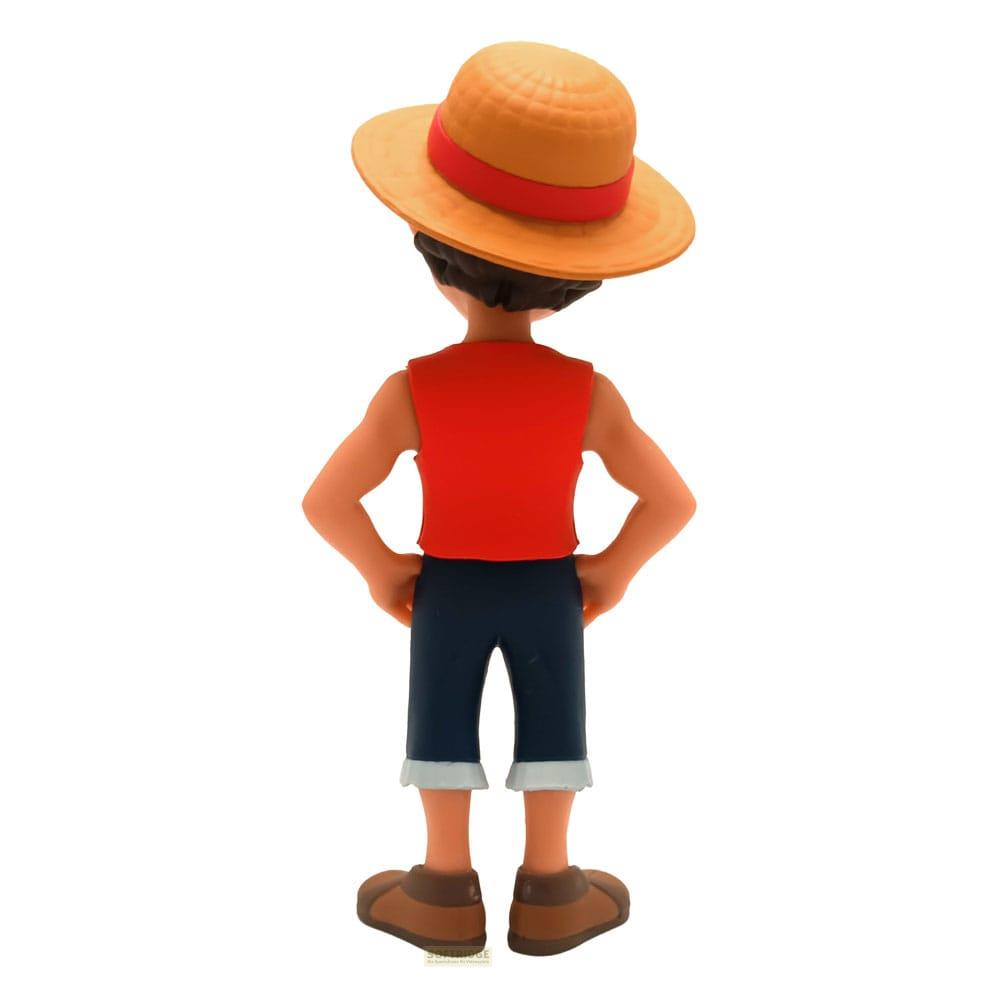 Figura de espaldas, con chaleco rojo, pantalones azules y sombrero.