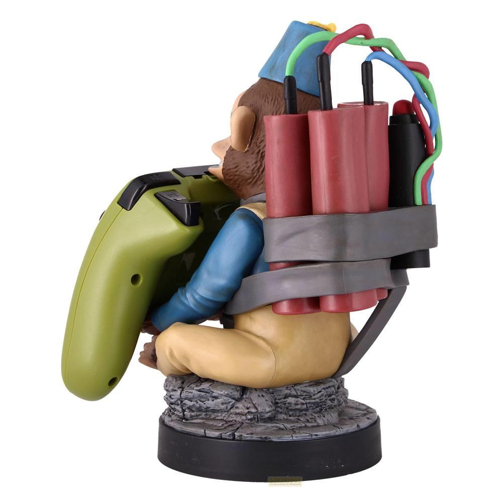 Ein Affe mit einem grünen Controller und Dynamit auf dem Rücken sitzt auf einem Felsen.
