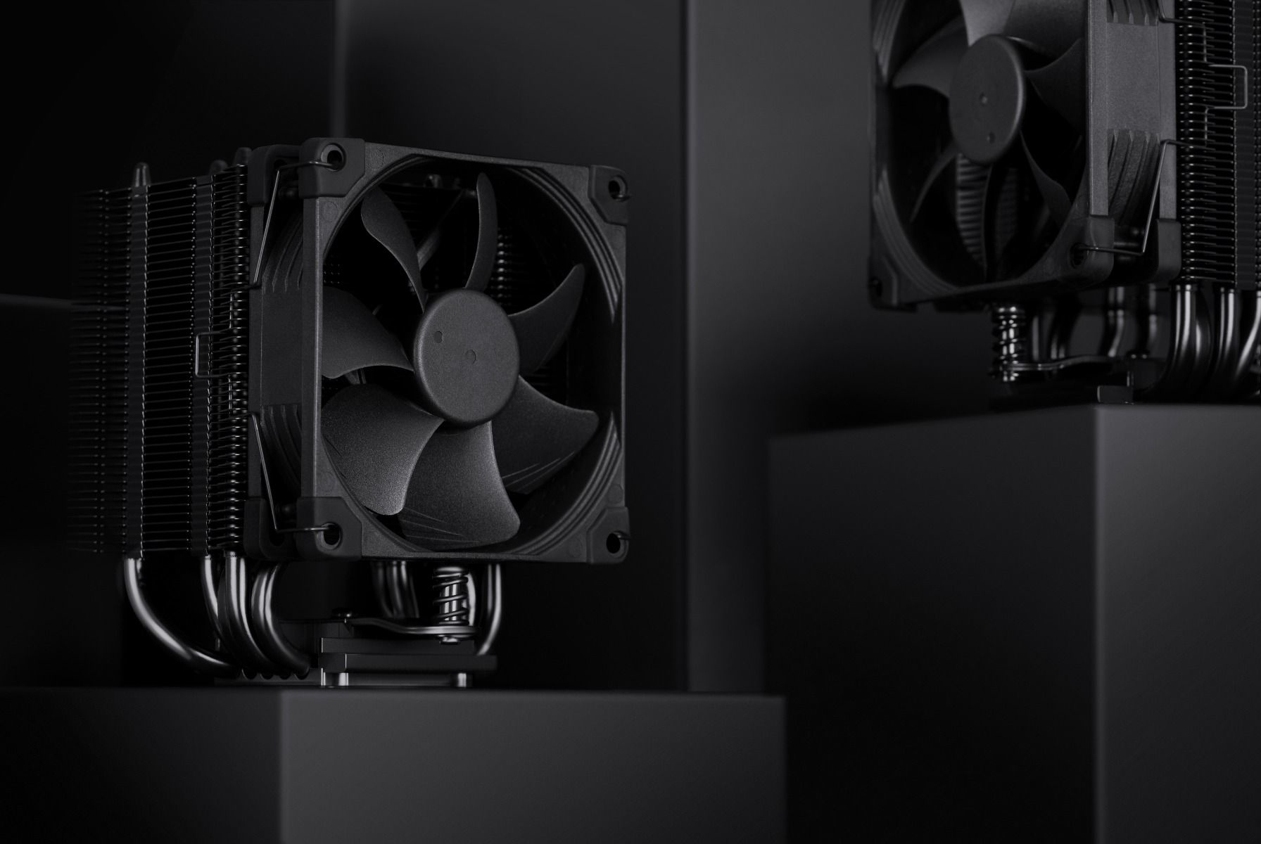 Dissipatore CPU nero con ventola su sfondo scuro, primo piano.