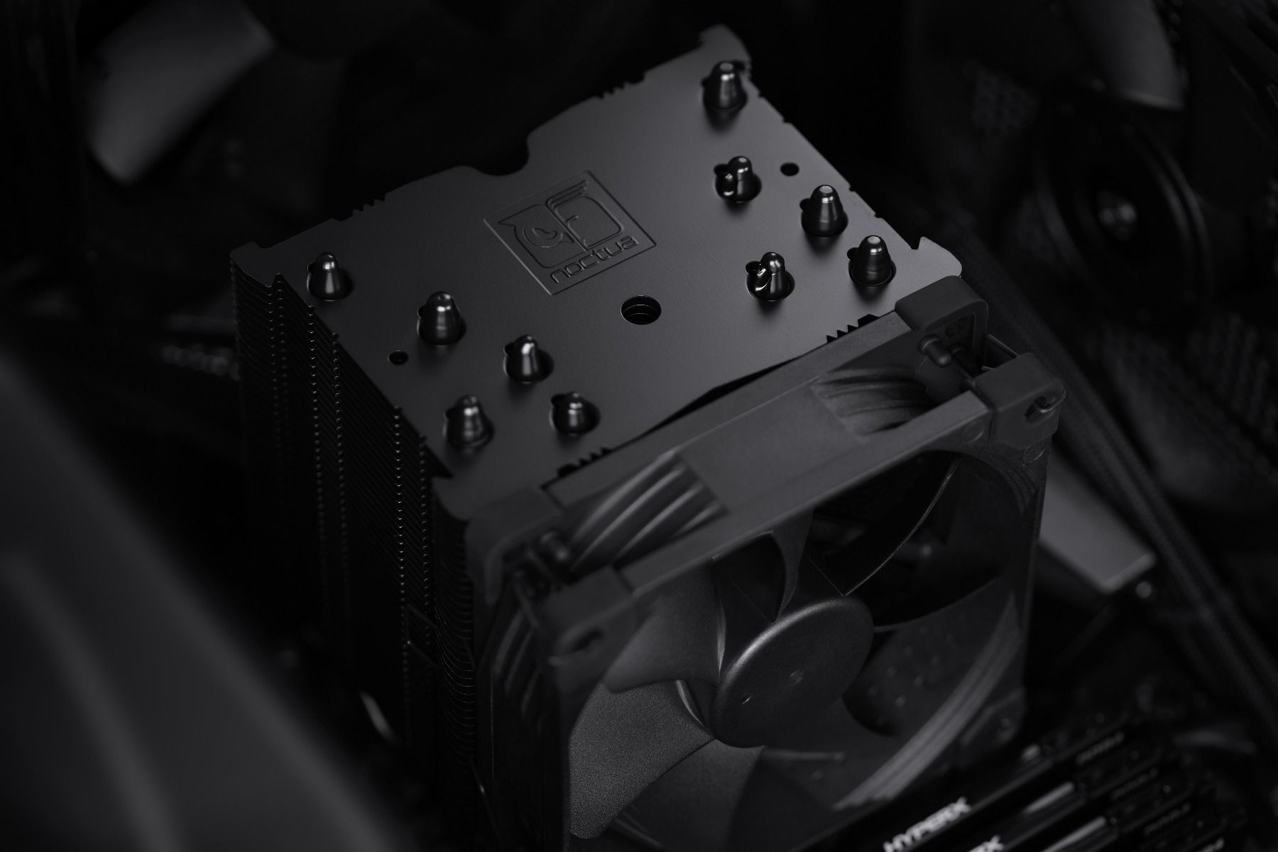 Dissipatore CPU nero con ventola e logo del marchio, su una scheda madre.