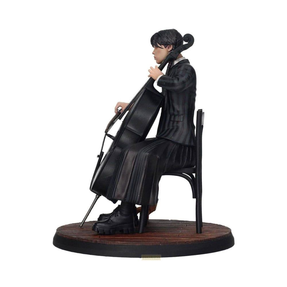 Figura toca el violonchelo sobre base de madera, viste vestido negro y botas.