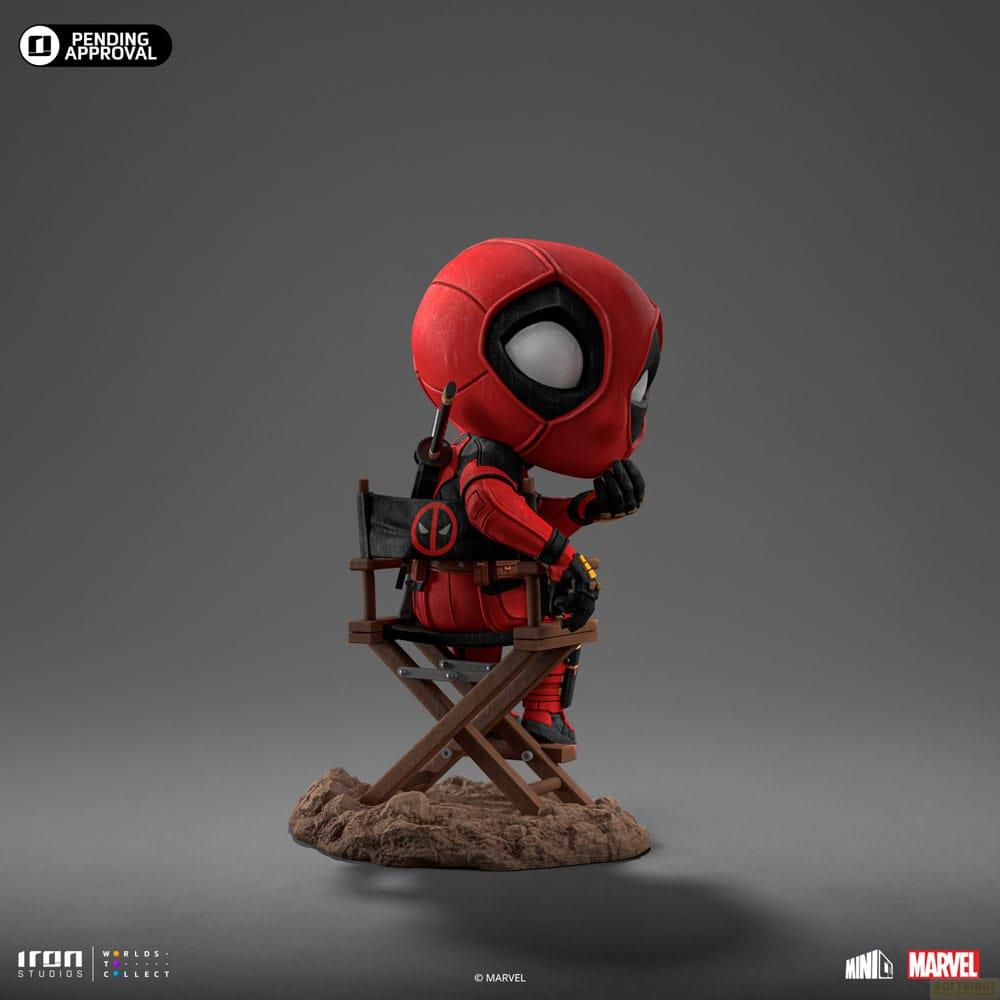 Una figura di Deadpool seduta su una sedia da regista su una base terrosa.