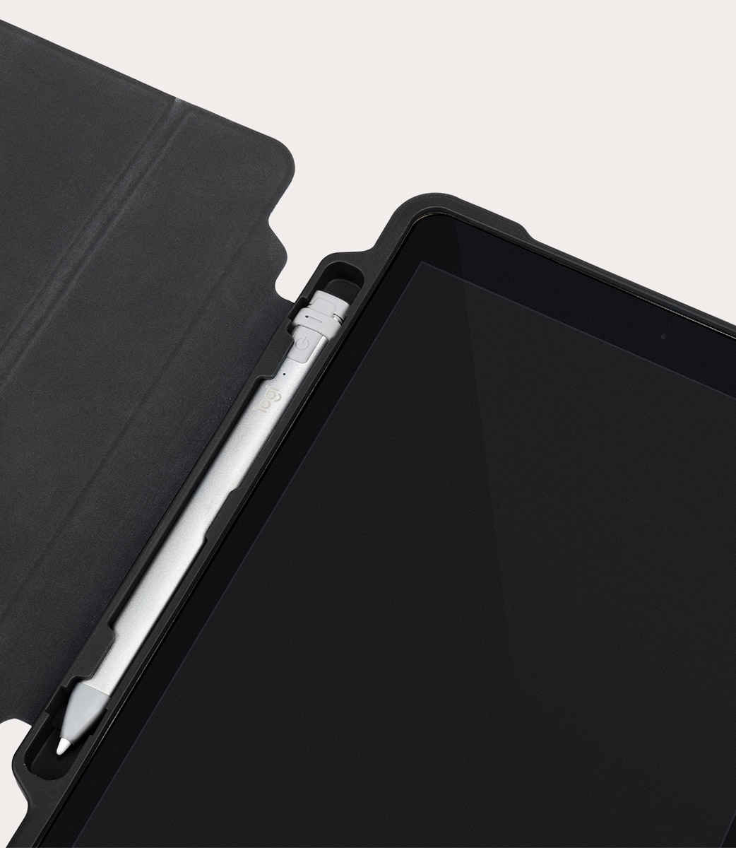 Stilo argentato in supporto nero accanto a schermo tablet scuro.