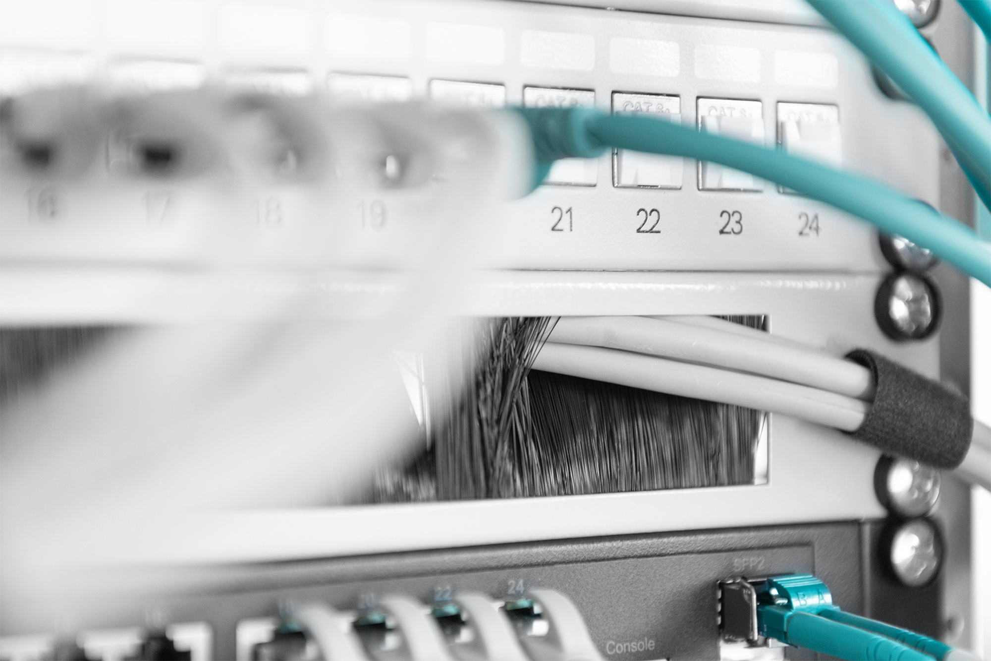 Un patch panel di rete con molti cavi e porte, numerati da 16 a 24.