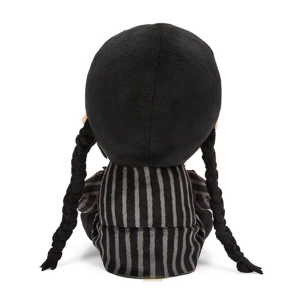 Un peluche con trenzas negras y vestido a rayas está sentado.