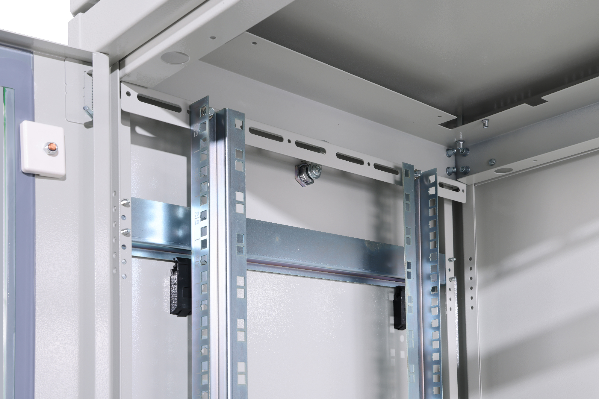 Innenansicht eines grauen Metallschranks mit Schienen und Halterungen.