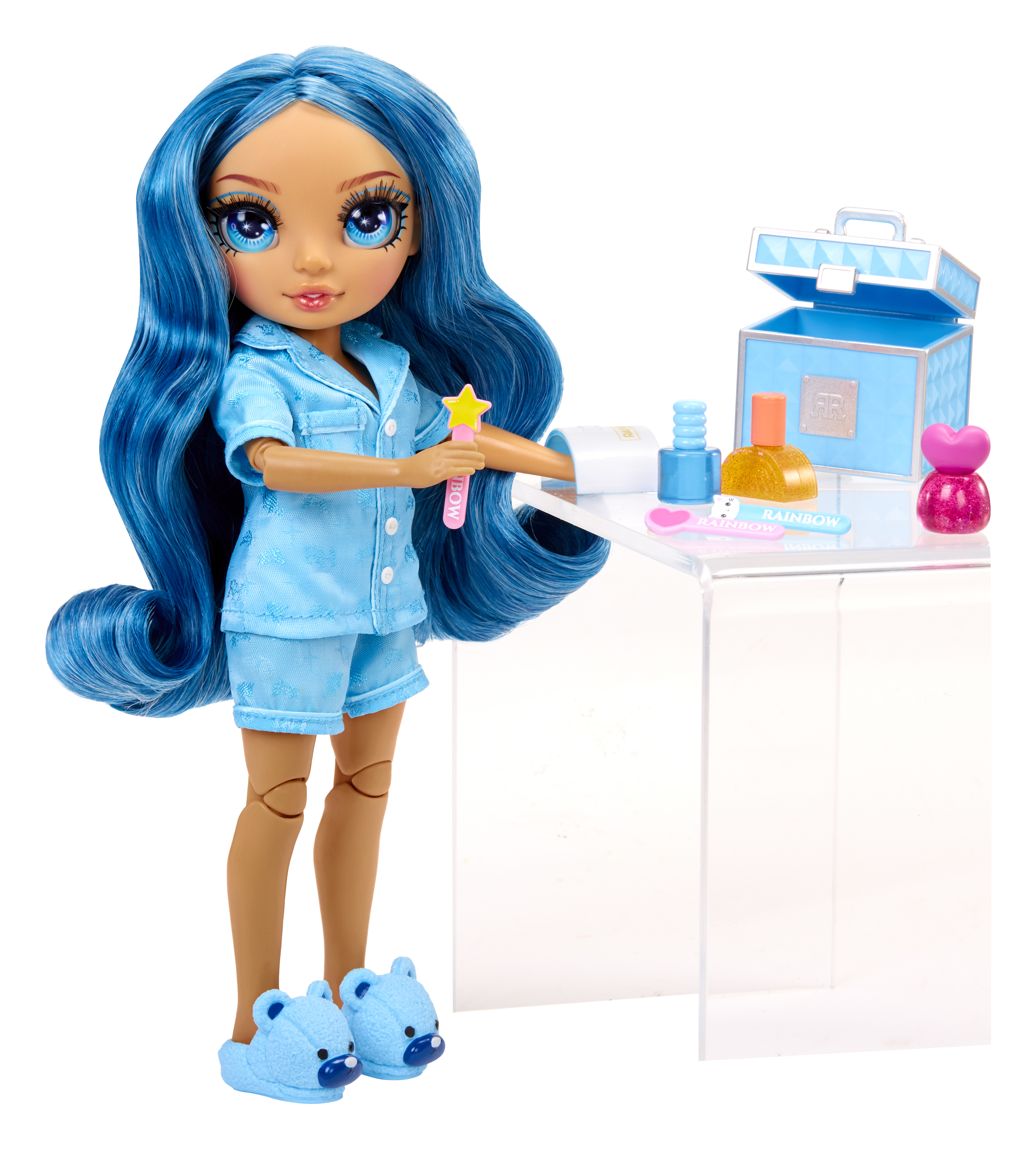 Una bambola con capelli blu e pigiama sta vicino a un tavolo con prodotti cosmetici.