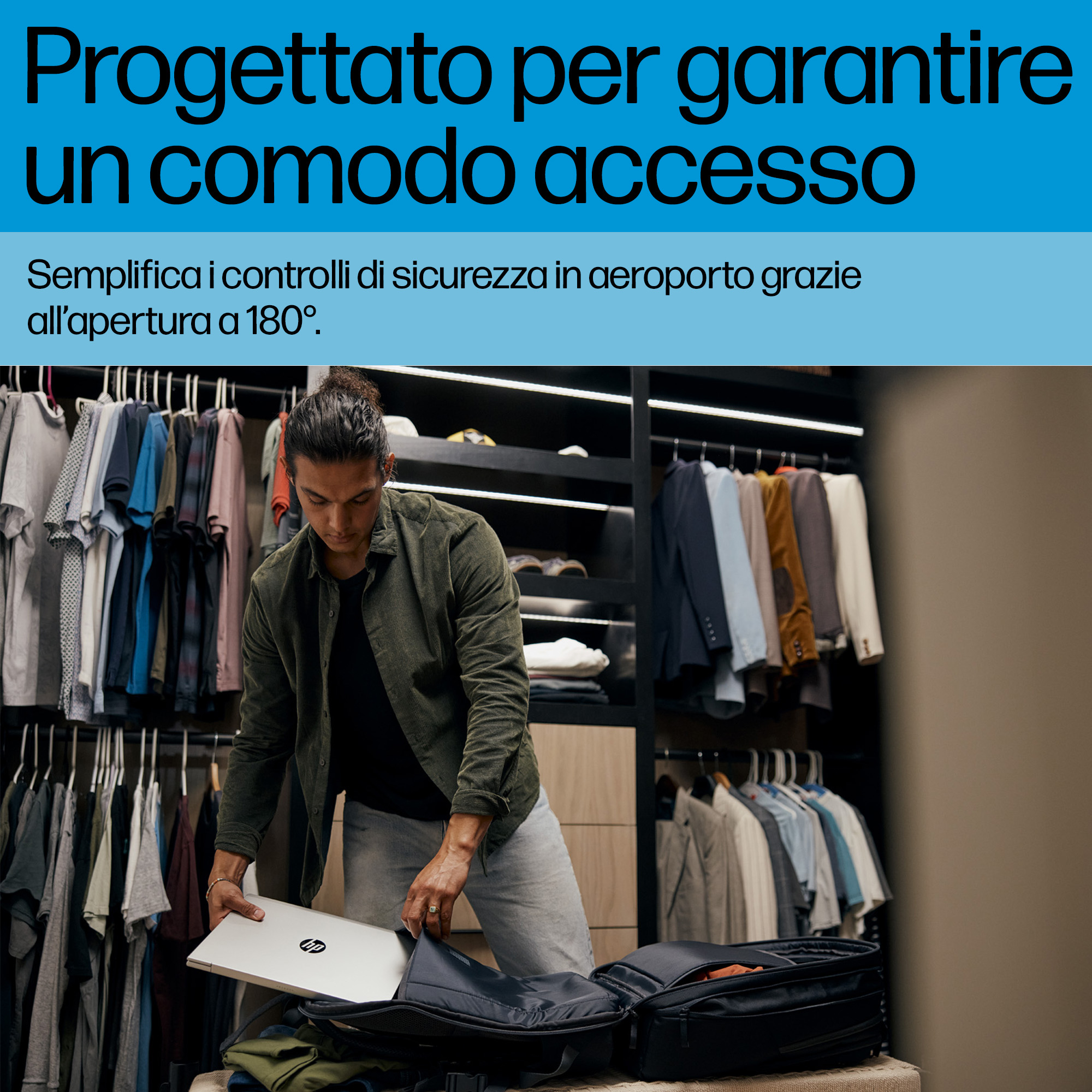 Uomo che mette laptop in borsa davanti ad armadio con vestiti.