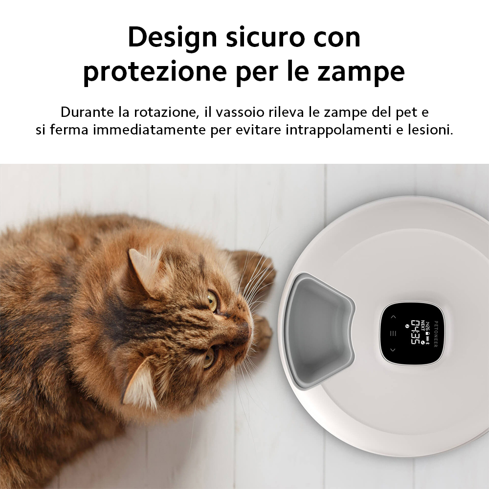 Kot leży obok białego podajnika karmy z wyświetlaczem.