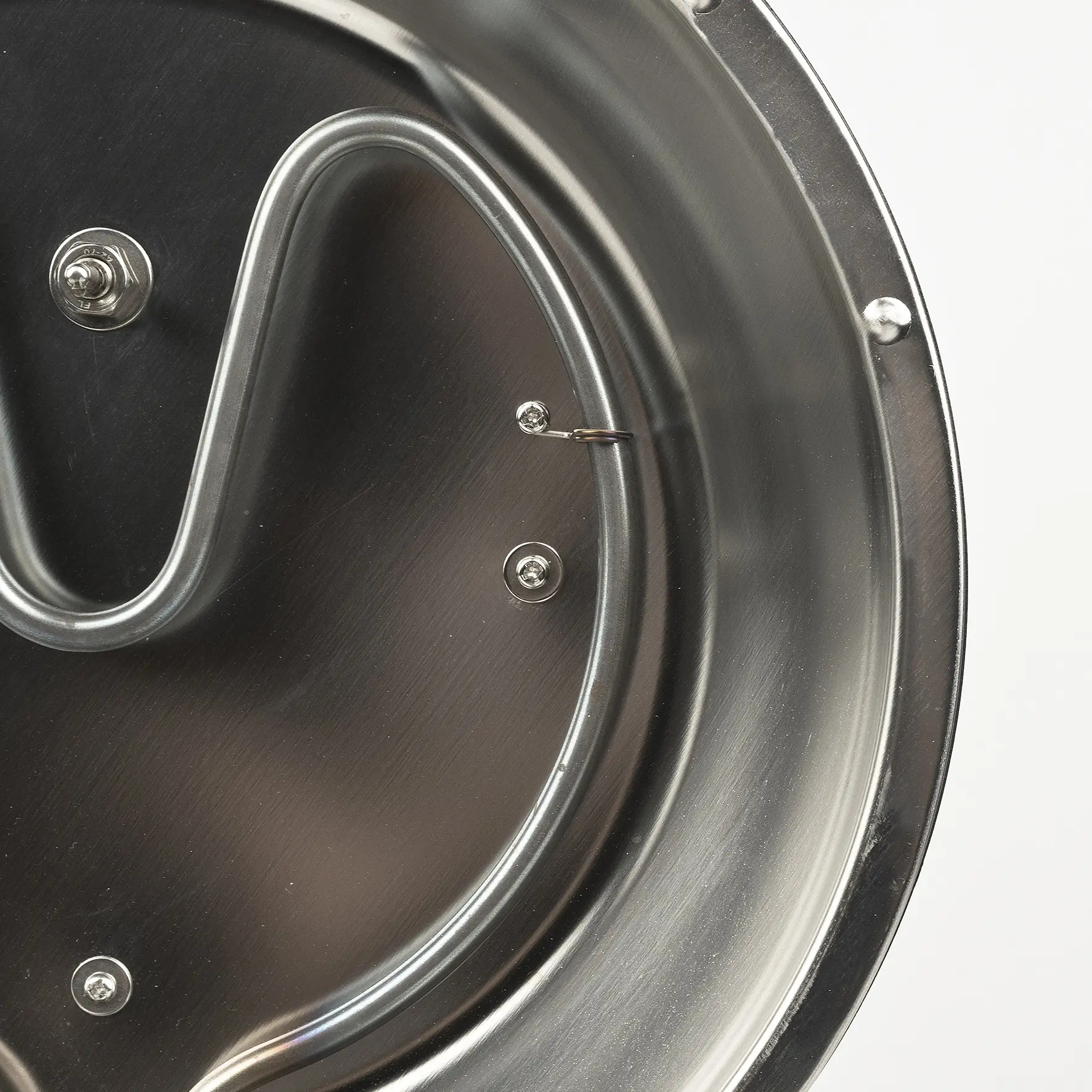 Nahaufnahme eines silbernen Metallbehälters mit einer gewundenen Heizspirale und Schrauben.