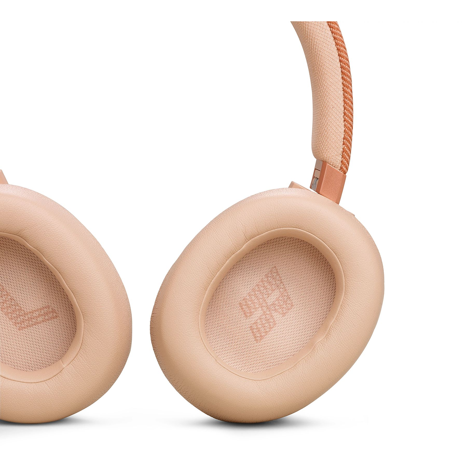 Zbliżenie beżowych słuchawek nausznych z różowo-złotymi akcentami i materiałową opaską.