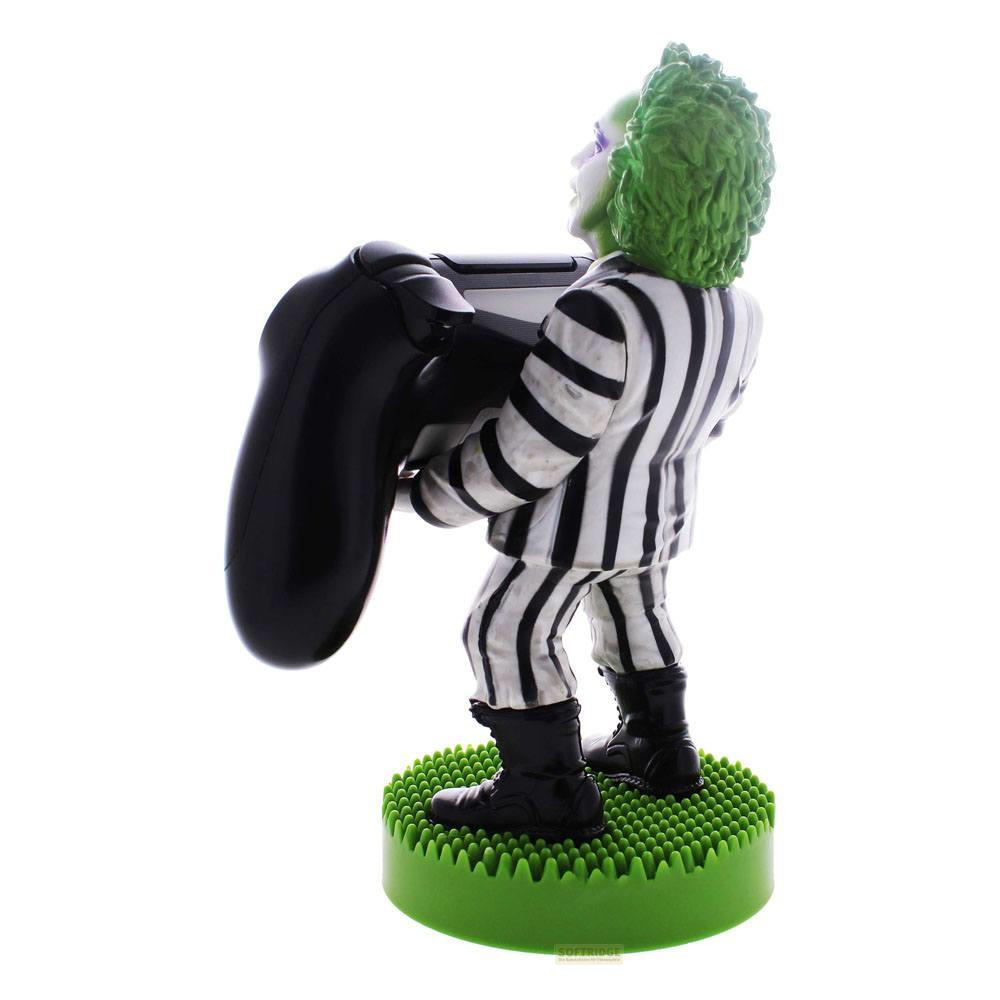 Beetlejuice-Figur hält schwarzen Controller, steht auf gr&uuml;ner Basis.