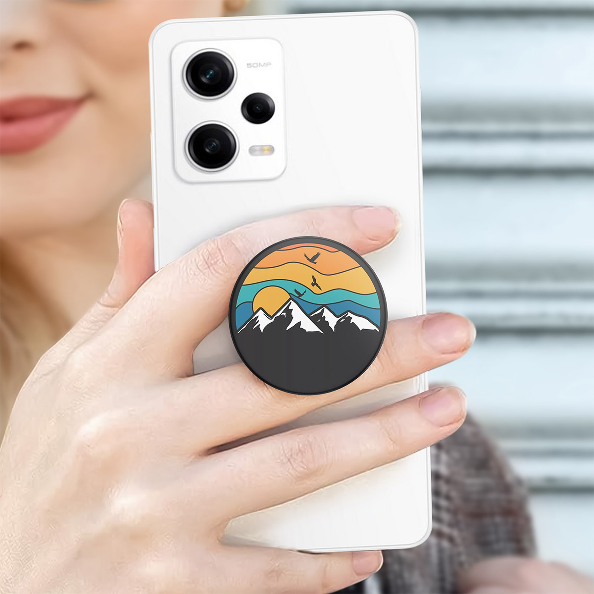 Uno smartphone con un'impugnatura con design tramonto montano.