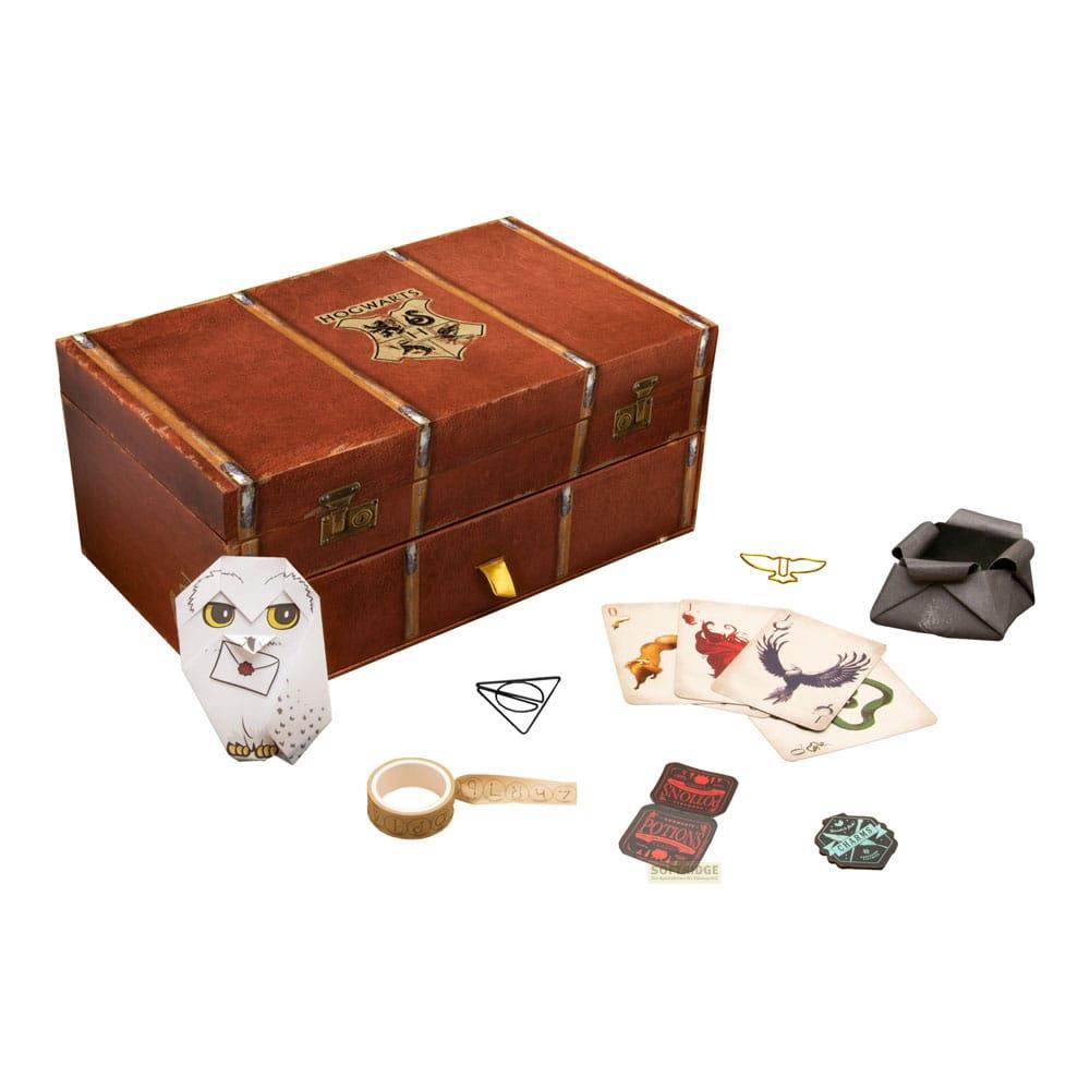 Un baúl marrón con escudo de Hogwarts, lechuza de papel, cartas, cinta y dados.