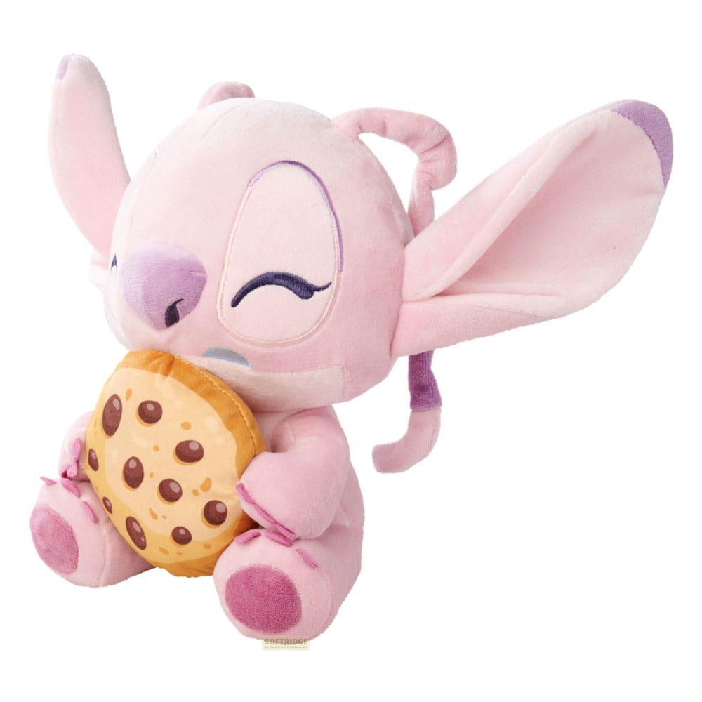 Un peluche Stitch rosa tiene un biscotto. Sembra morbido e carino.