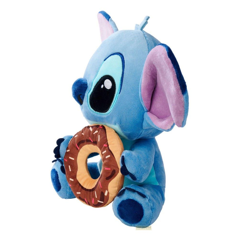 Ein blauer Stitch-Plüsch hält einen Schokoladendonut mit Streuseln.