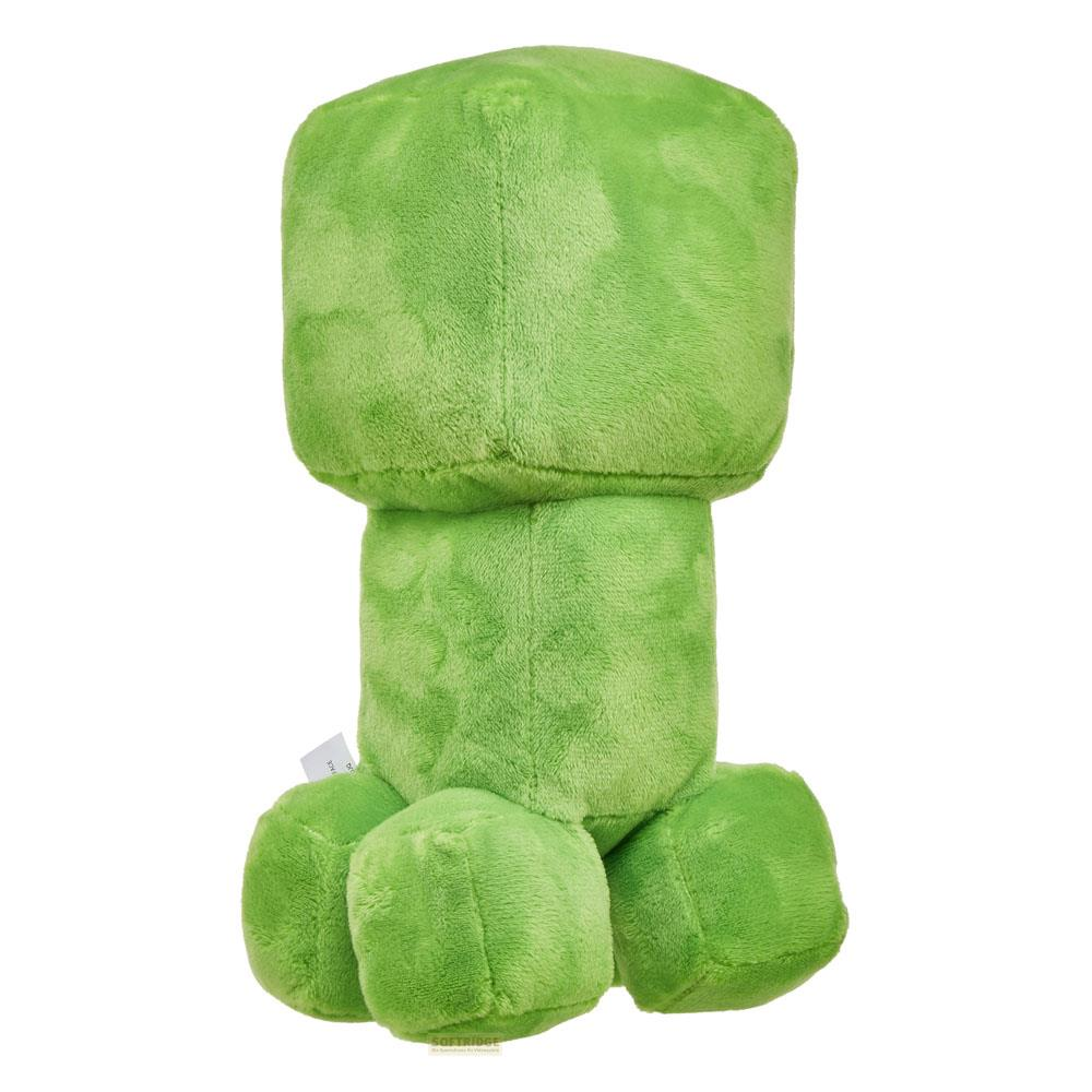 Ein grünes, kubisches Minecraft Creeper-Plüschtier steht.