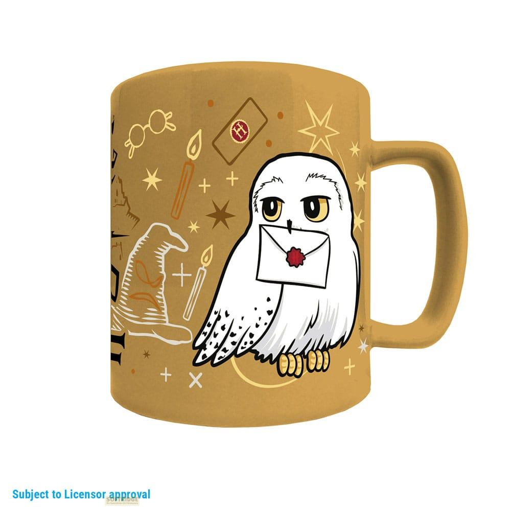 Eine goldene Tasse mit einem weißen Uhu, der einen Brief hält, und Harry-Potter-Symbolen.