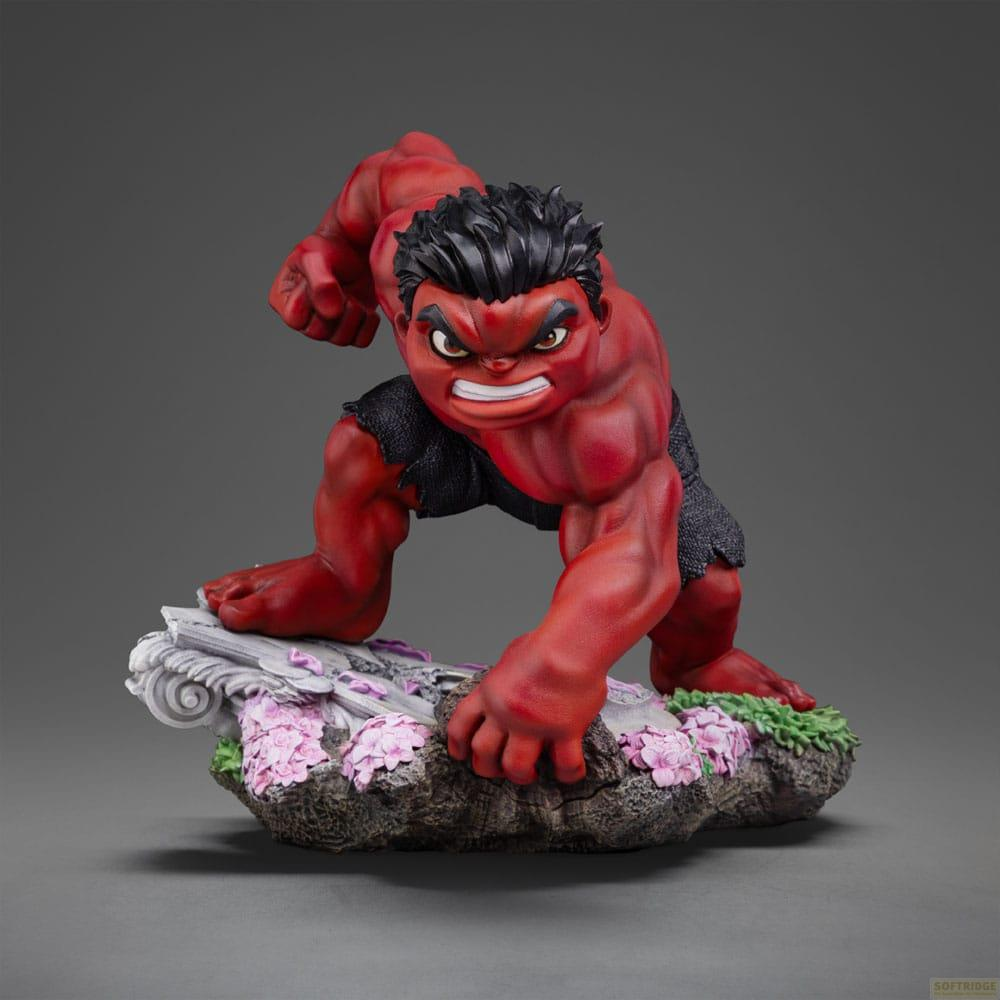 Statua di Red Hulk accovacciata su rocce con fiori, sfondo scuro.