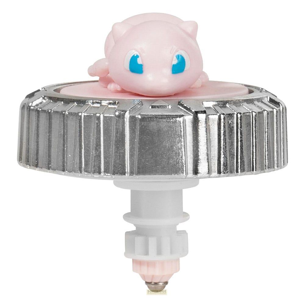 Une figurine rose de Mew repose sur une toupie argentée à manche blanc.