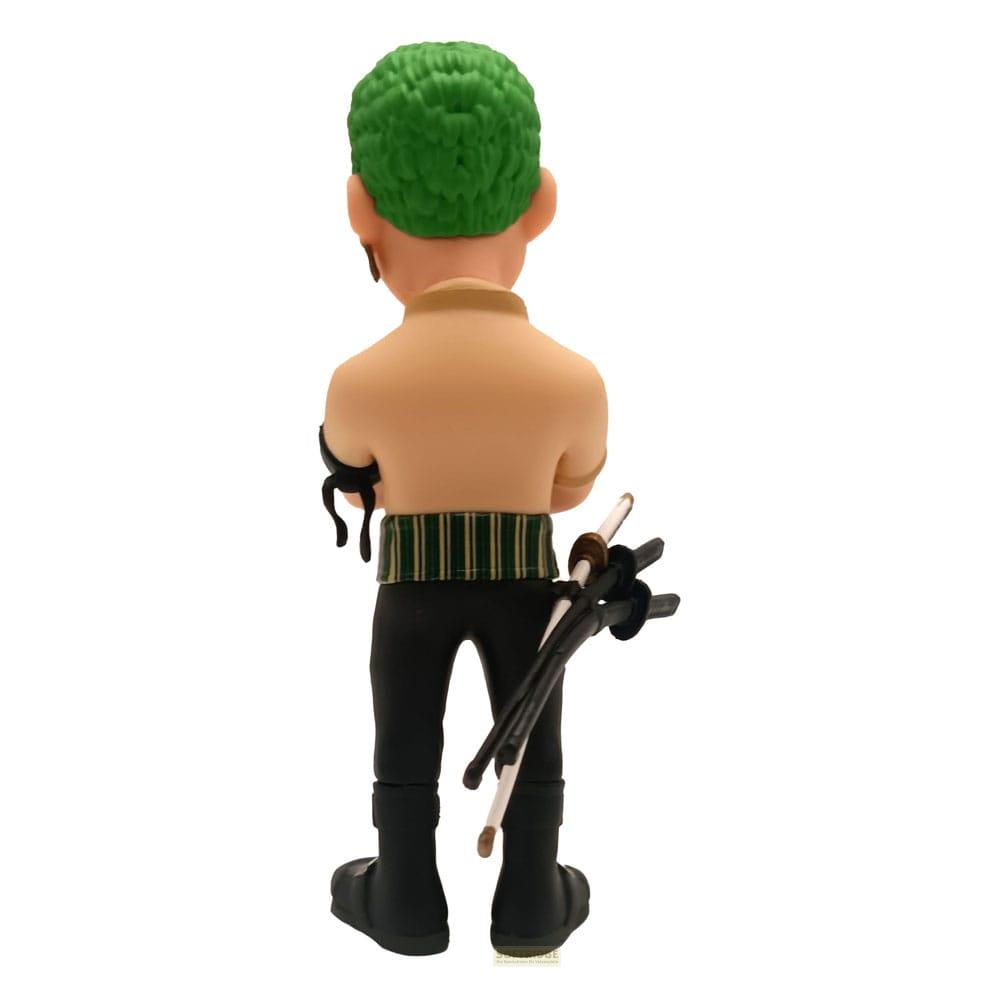 Una figura de espaldas con pelo verde, camisa beige, pantalones negros y tres espadas.