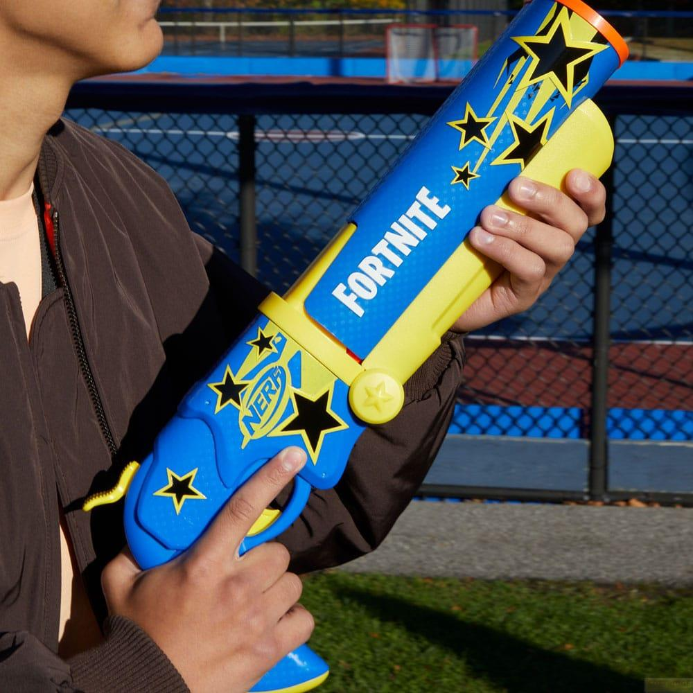 Persona sosteniendo una pistola de agua Nerf Fortnite azul y amarilla con estrellas.