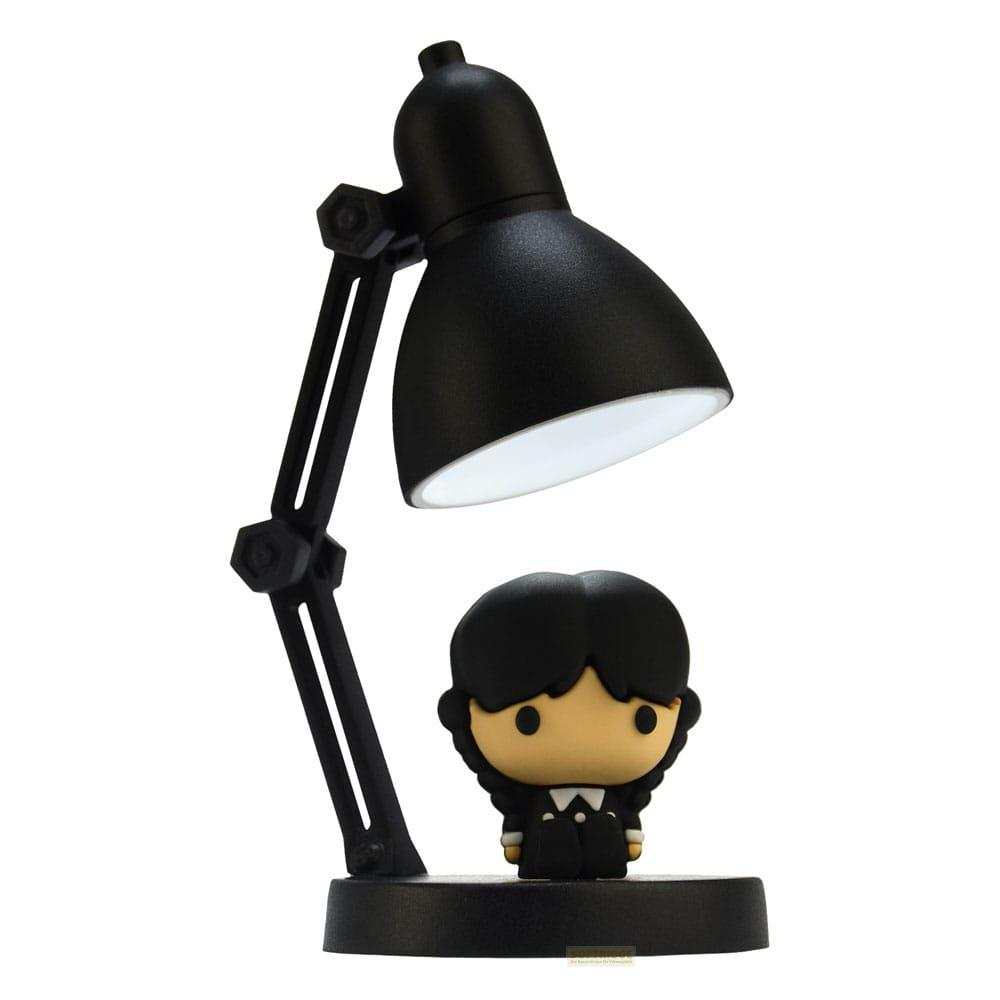 Una lámpara de escritorio negra ilumina una figura pequeña.