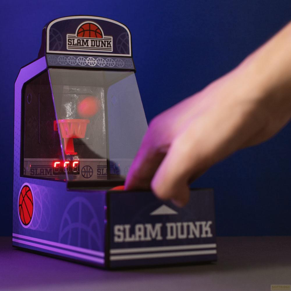 Ein Hand bedient ein Slam Dunk Spielzeug mit Basketball und rotem Korb.