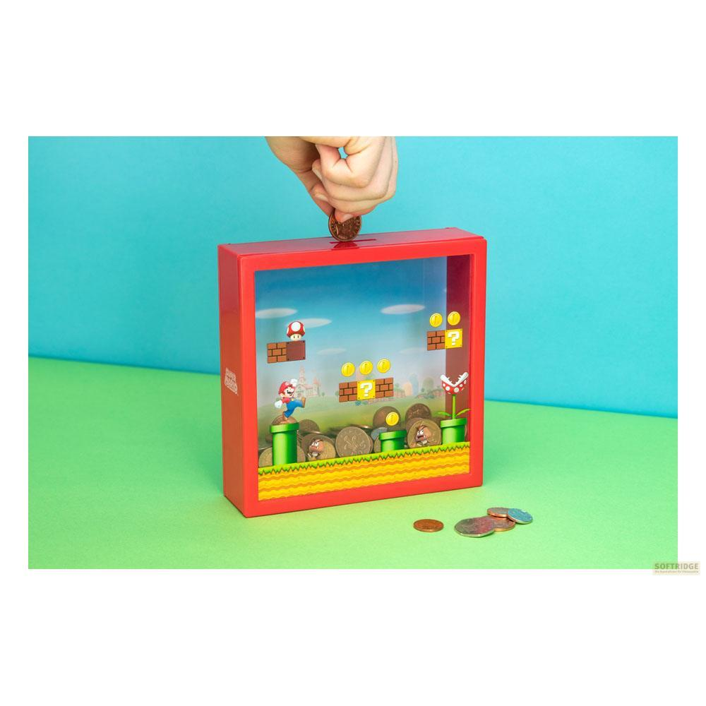 Una mano lascia cadere una moneta in un salvadanaio rosso Mario con scena di gioco.