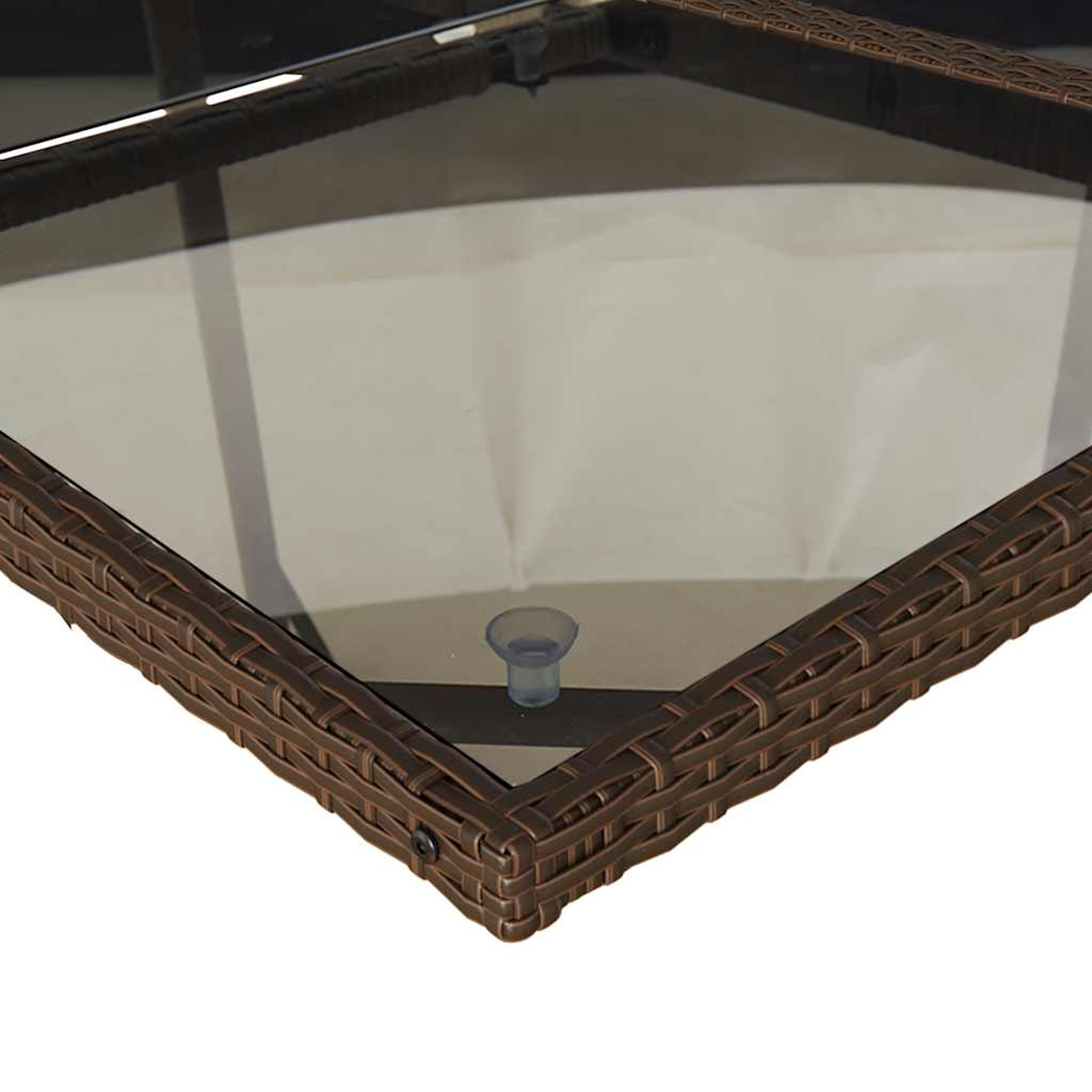 Nahaufnahme einer braunen Rattan-Tischkante mit Glasplatte und Saugnapf.
