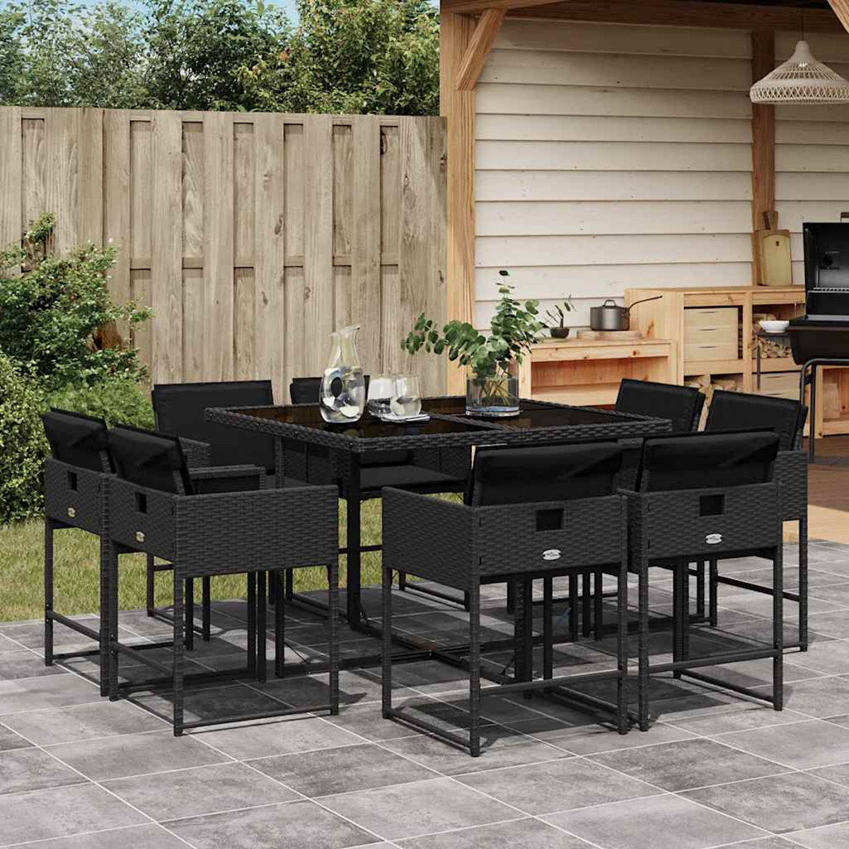 Ein schwarzes Rattan-Ess-Set mit acht Stühlen und einem Tisch im Freien.