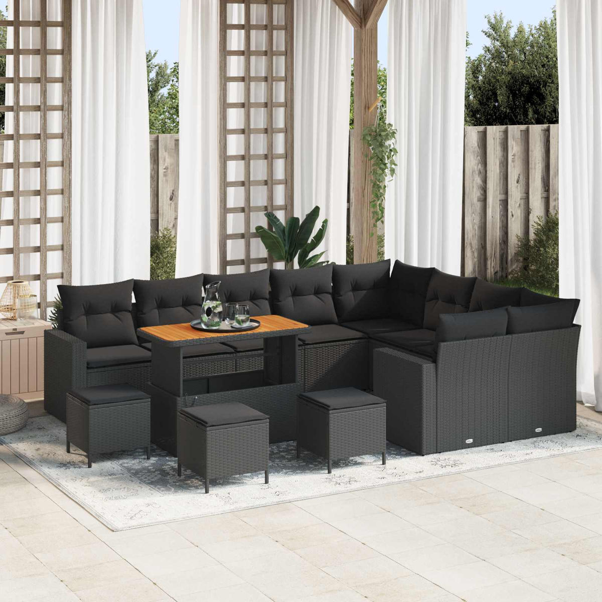 Dunkelgraue Rattan-Gartenlounge mit schwarzen Kissen und einem Holztisch.