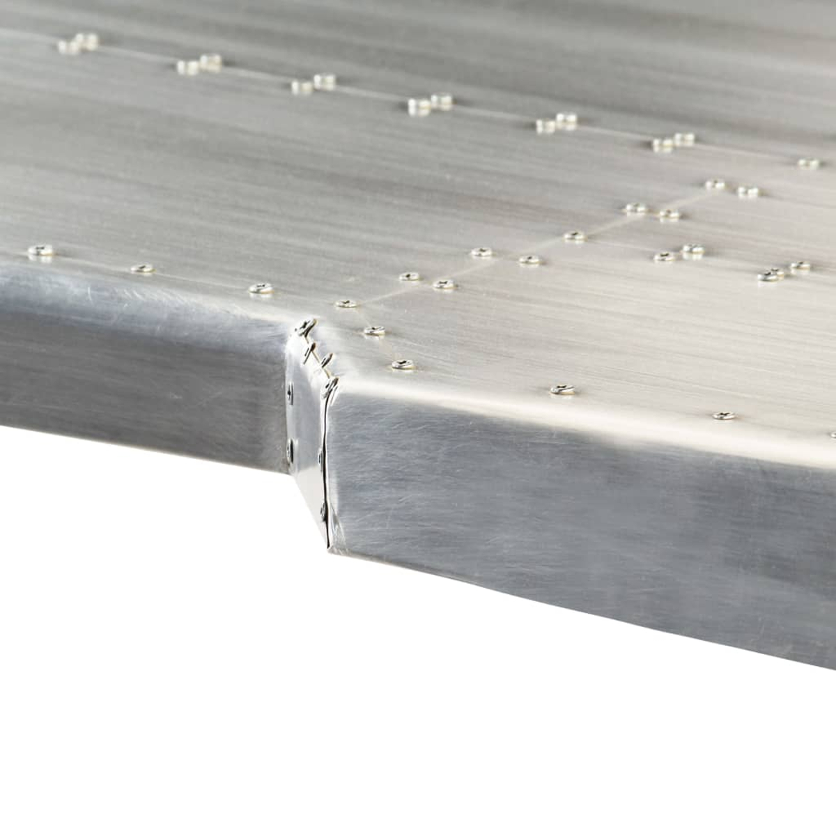 Detailaufnahme von Nieten auf einer gebürsteten Metalloberfläche, die eine Kante bildet.