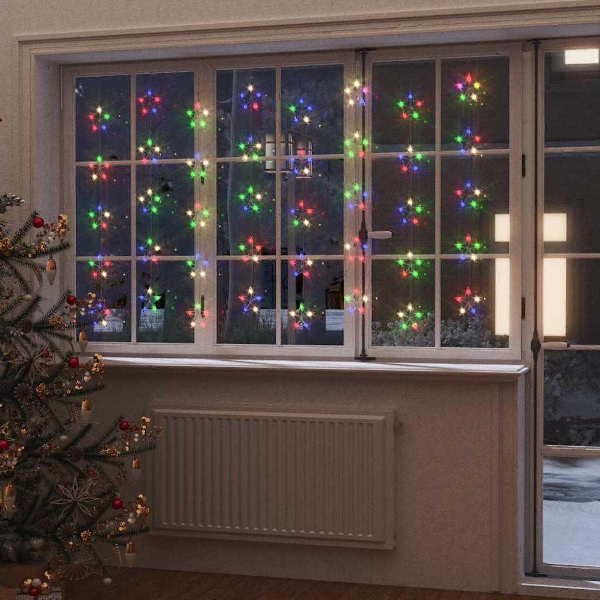 Bunte Sternenlichter hängen vor einem Fenster mit Blick auf Bäume im Freien.