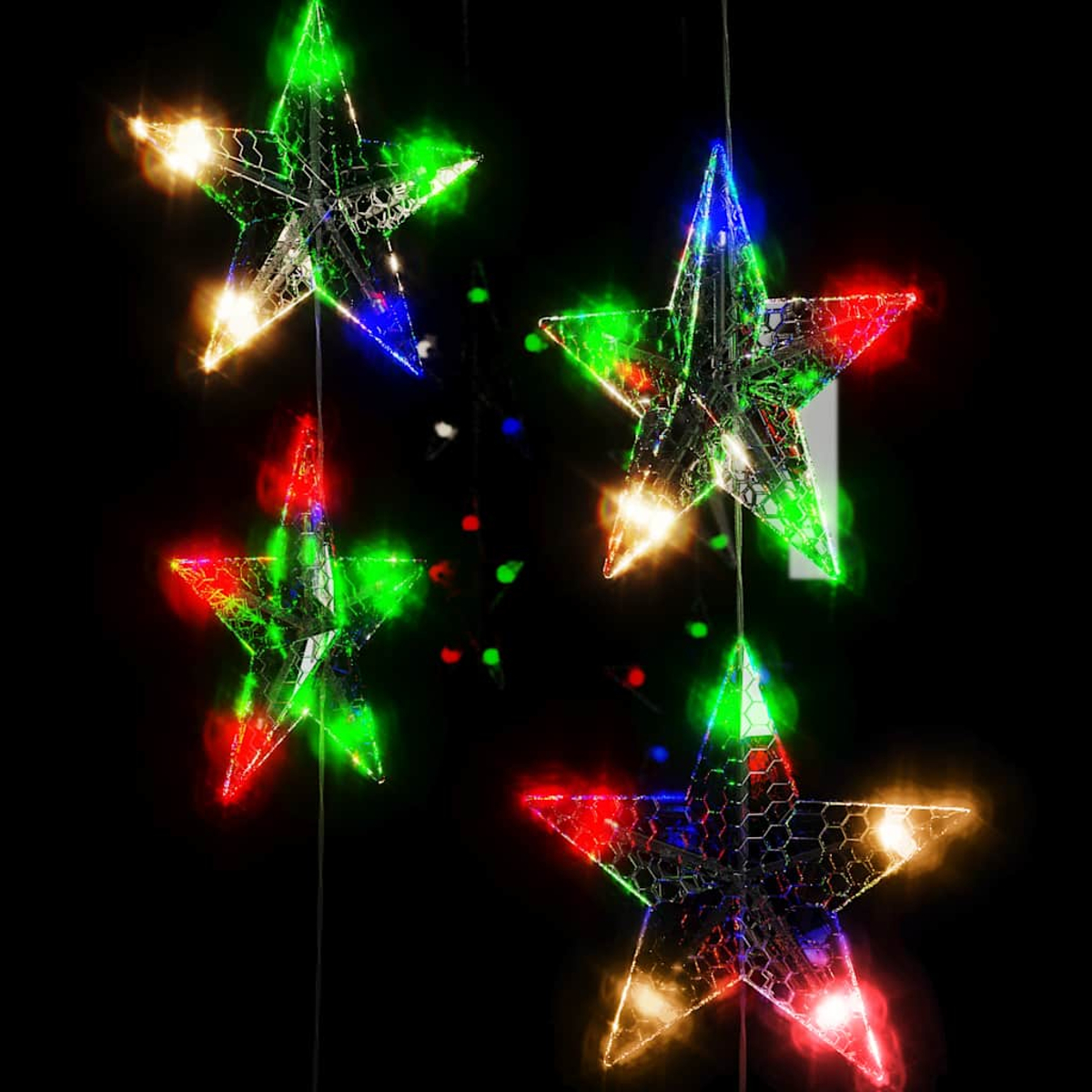 Vier leuchtende Sternlichter mit roten, grünen und blauen Lichtern auf schwarzem Hintergrund.