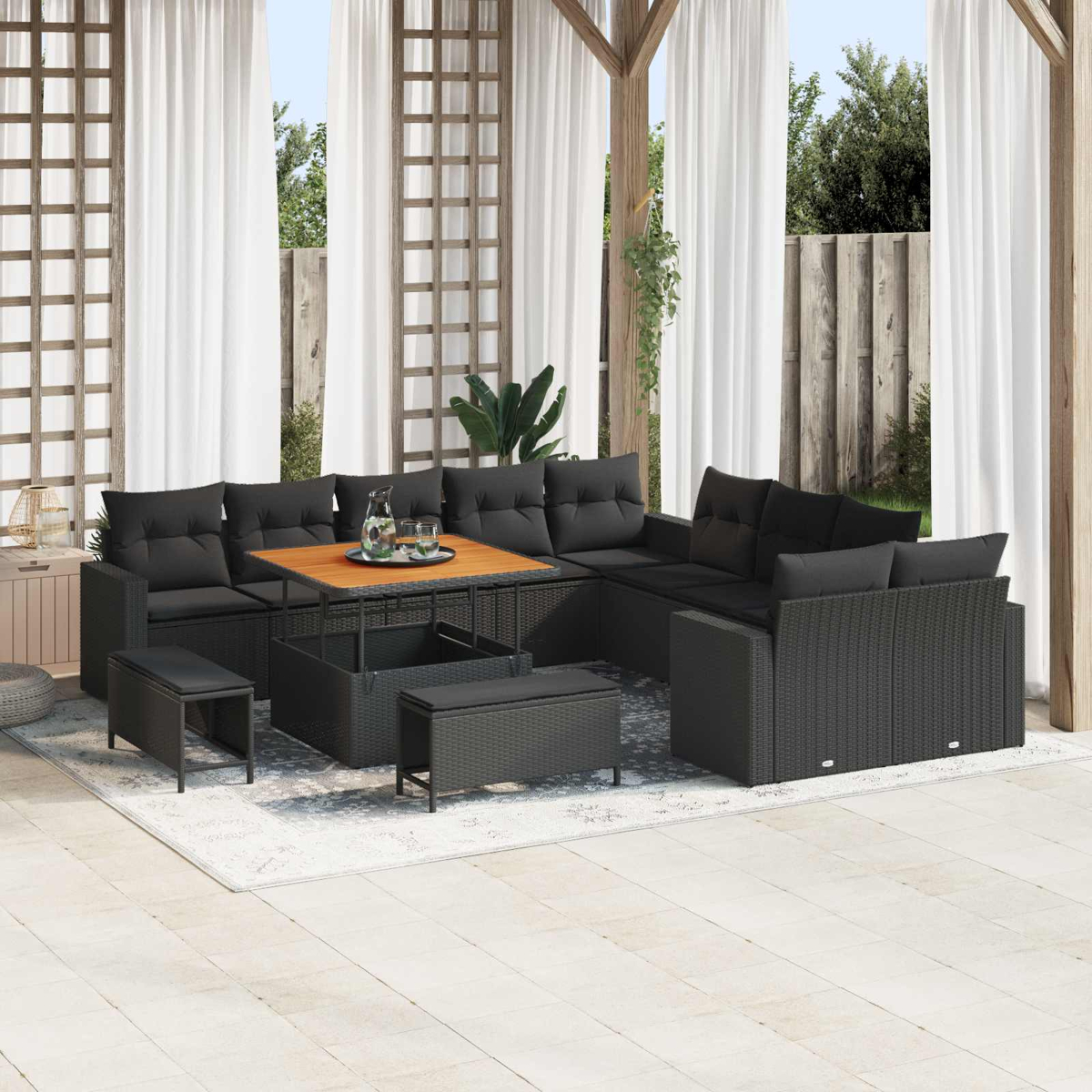 Dunkles Rattan-Sofa-Set mit Tisch auf einer Terrasse unter einem Baldachin.