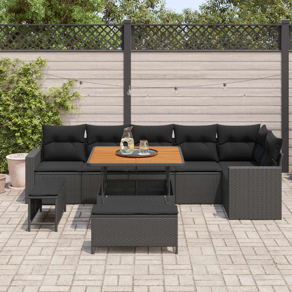 Dunkelgraue Lounge-Garnitur mit schwarzen Kissen auf einer Terrasse.